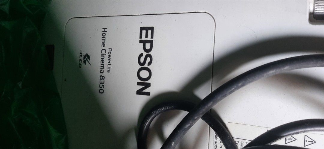 Epson Home Cinema 8350 Projector (Category: Projectors) located in Las Pinas. Submitted by 030700 (Listing ID 1422272752, Image 2). Description: - Epson Home Cinema 8350 projector - Includes power cable - Features lens adjustment dial - White unit - Epson logo visible - Model number clearly printed - Manual and remote control !!! Relocating/Moving Soon !!! Most items posted have been stored for a decade or longer hence the discoloration or stain 