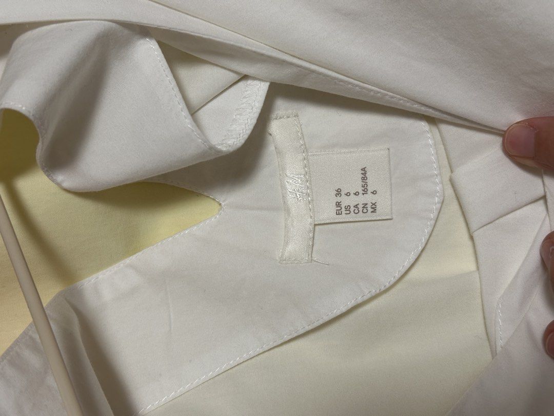 H&M V-neck ruffled wing sleeves blouse (Category: Blouses) located in Quezon City. Submitted by declutters.bianca (Listing ID 1422343334, Image 2). Description: H&M V-neck ruffled wing sleeves blouse white with orange band at the backpack RFS: Decluttering 📍QC/BGC/Makati.