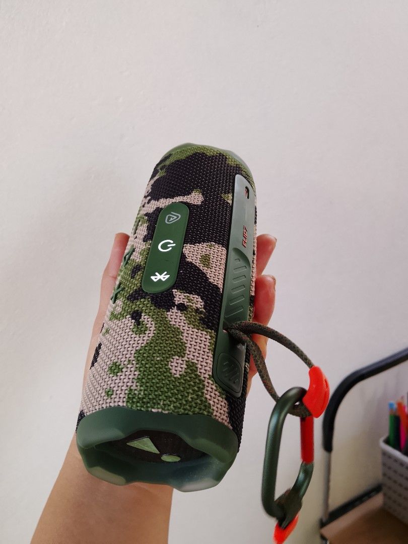 JBL Flip 7 by Harman Bluetooth Speaker (Category: Soundbars, Speakers & Amplifiers) located in San Fernando. Submitted by jseyl (Listing ID 1422248373, Image 2). Description: - JBL Flip 7portable Bluetooth speaker - Camouflage design (green and black) - Built-in carabiner for easy attachment - Power and Bluetooth pairing buttons - JBL logo visible.