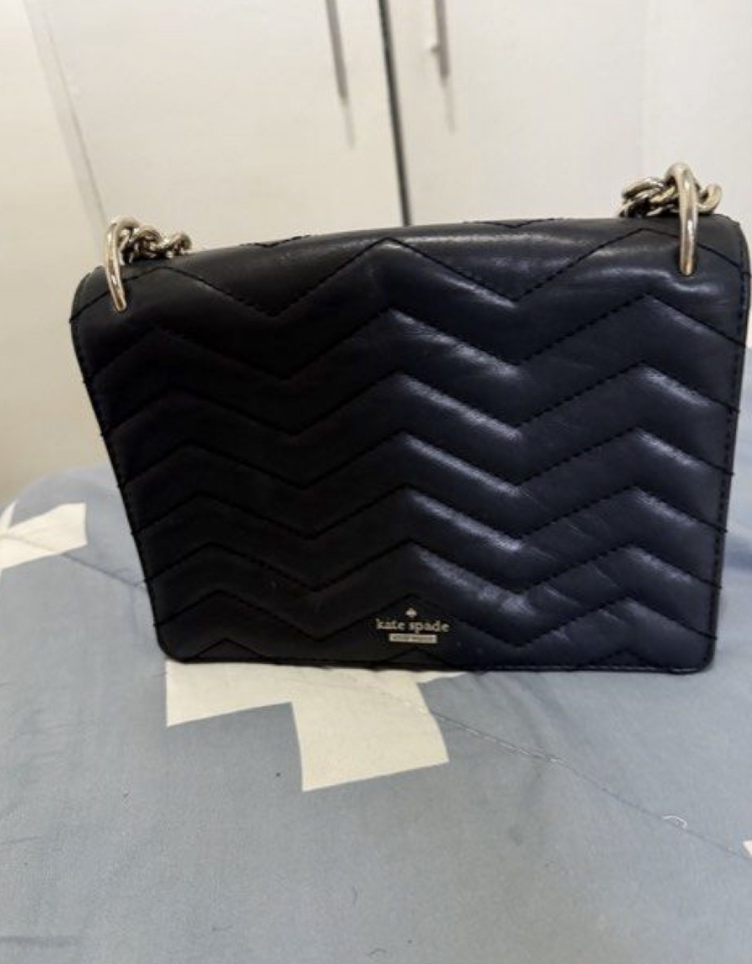 Kate Spade Black Chevron Shoulder Bag (Category: Luxury Bags & Wallets) located in Manila. Submitted by tidytrends_25 (Listing ID 1422261709, Image 2). Description: - Kate Spade shoulder bag - Chevron pattern - Silver chain strap - Flap closure - Includes dust bag - Pink interior lining - Some stains inside.