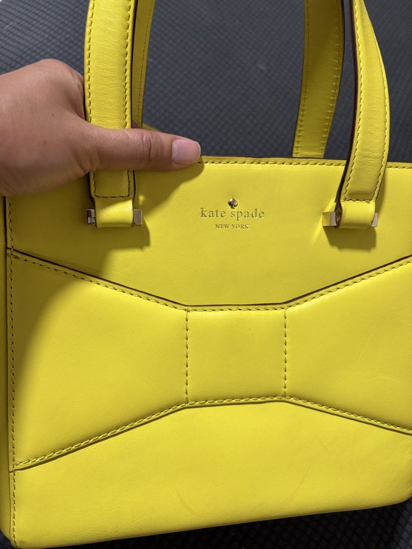 Kate Spade New York Bow Satchel (Category: Luxury Bags & Wallets) located in Manila. Submitted by dmmai (Listing ID 1422354627, Image 3). Description: - Bright yellow Kate Spade satchel - Bow detail on the front - Top handle and detachable shoulder strap - Polka dot lining - Silver hardware - Zipper closure - Protective metal feet Flaws as in the pictures, very minor, overall still a great bag.