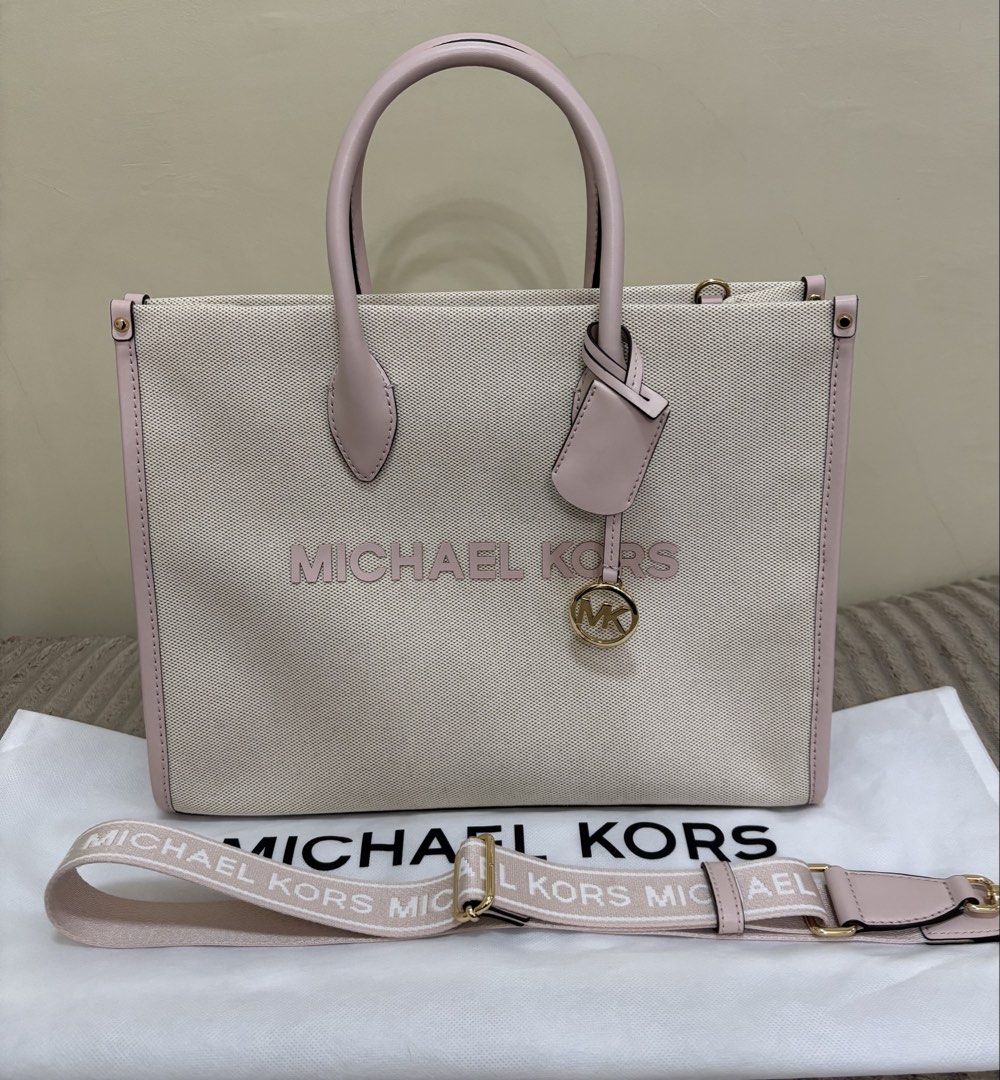 Michael Kors Mirella Canvas Tote Bag (Category: Luxury Bags & Wallets) located in Batangas. Submitted by jmmac (Listing ID 1422245860, Image 1). Description: - Michael Kors tote bag - Canvas exterior - Pink leather accents and handles - Detachable shoulder strap with Michael Kors logo - Lined interior - Zippered pocket - Detachable charm.