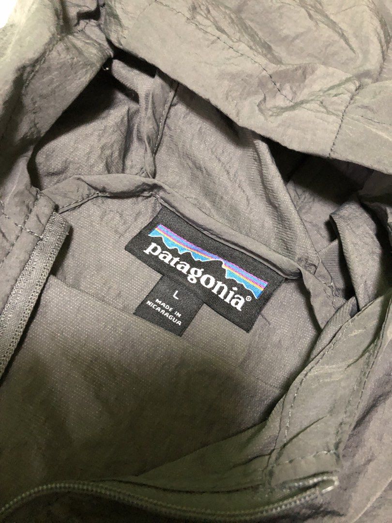 Patagonia Lightweight Jacket with Hood (Category: Coats, Jackets and Outerwear) located in San Francisco. Submitted by thriftraphy (Listing ID 1422297806, Image 3). Description: - Patagonia jacket, size Large - Full zip closure - Attached hood - Solid grey color - Lightweight design - Patagonia logo on chest - Drawstring at bottom hem - Made in Nicaragua.
