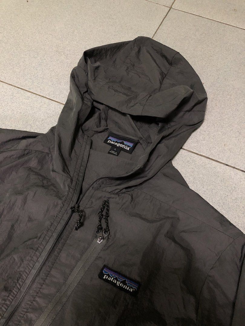 Patagonia Lightweight Jacket with Hood (Category: Coats, Jackets and Outerwear) located in San Francisco. Submitted by thriftraphy (Listing ID 1422297806, Image 1). Description: - Patagonia jacket, size Large - Full zip closure - Attached hood - Solid grey color - Lightweight design - Patagonia logo on chest - Drawstring at bottom hem - Made in Nicaragua.