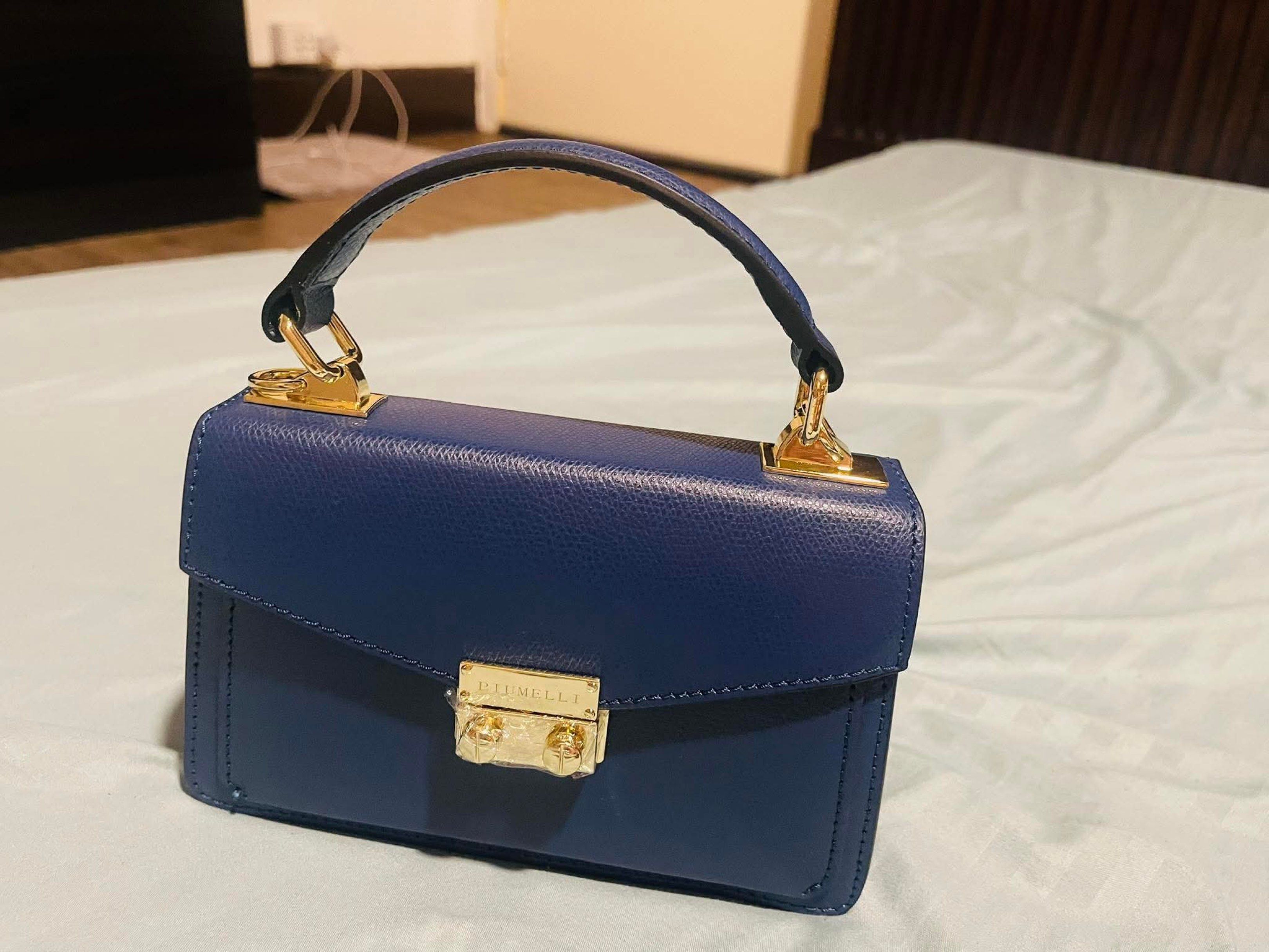 Piumelli Milano Navy Blue Handbag (Category: Luxury Bags & Wallets) located in Pateros City. Submitted by norskieonlineshop (Listing ID 1422276703, Image 3). Description: - Piumelli Milano navy blue handbag - Top handle and detachable shoulder strap - Includes a gold chain strap - Gold clasp closure - Structured design - Made of leather - Comes with a dust bag.