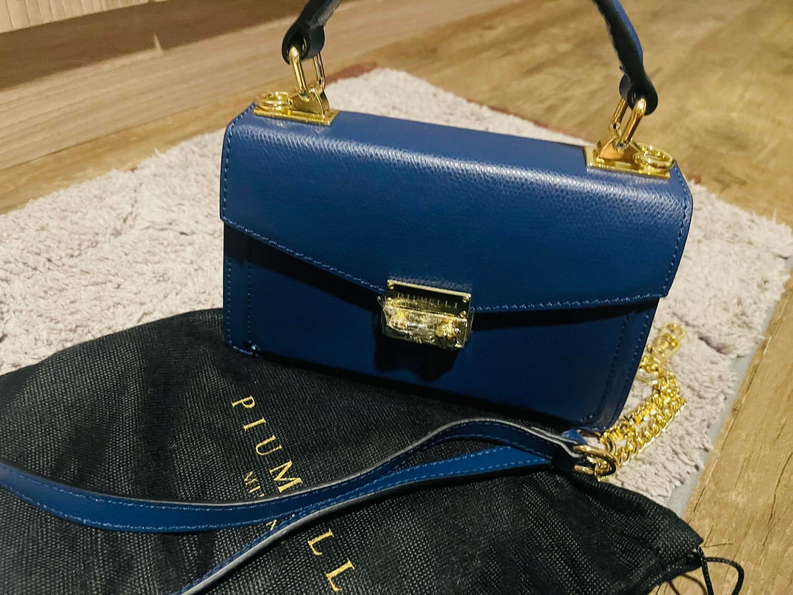 Piumelli Milano Navy Blue Handbag (Category: Luxury Bags & Wallets) located in Pateros City. Submitted by norskieonlineshop (Listing ID 1422276703, Image 1). Description: - Piumelli Milano navy blue handbag - Top handle and detachable shoulder strap - Includes a gold chain strap - Gold clasp closure - Structured design - Made of leather - Comes with a dust bag.