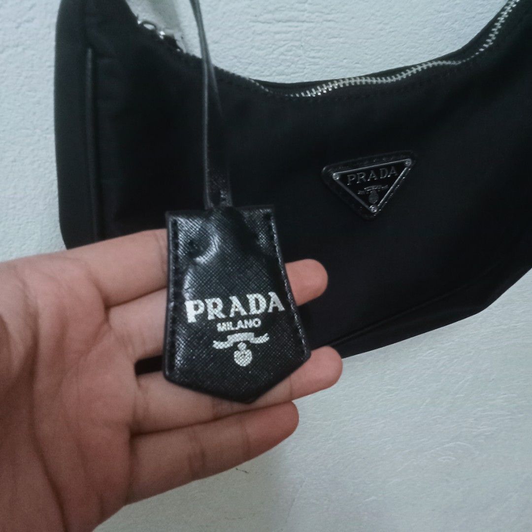 Prada Black Nylon Shoulder Bag (Category: Luxury Bags & Wallets) located in Manila. Submitted by jaylordfermilan (Listing ID 1422308675, Image 2). Description: - Black nylon shoulder bag - Silver-tone hardware - Chain strap - Prada logo on front - Prada logo lining - Zipper closure - Includes Prada tag.