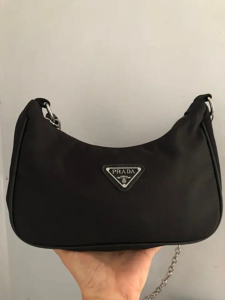 Prada Black Nylon Shoulder Bag (Category: Luxury Bags & Wallets) located in Manila. Submitted by jaylordfermilan (Listing ID 1422308675, Image 1). Description: - Black nylon shoulder bag - Silver-tone hardware - Chain strap - Prada logo on front - Prada logo lining - Zipper closure - Includes Prada tag.