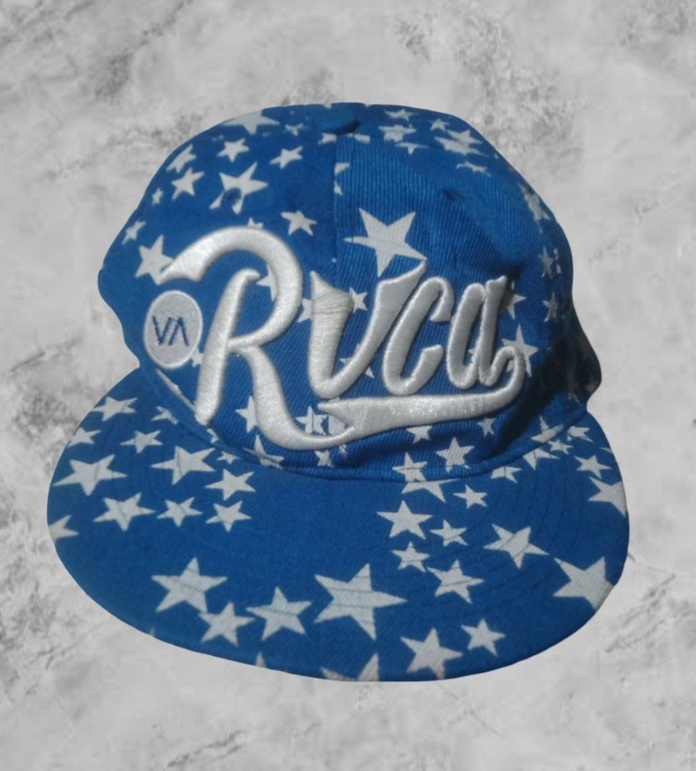 RVCA Star Print Cap (Category: Caps & Hats) located in Aroroy. Submitted by abouttocome (Listing ID 1422240017, Image 1). Description: - RVCA cap - Blue base with white star pattern - White RVCA logo on front - Red and white striped underside of brim - Adjustable strap for a custom fit.