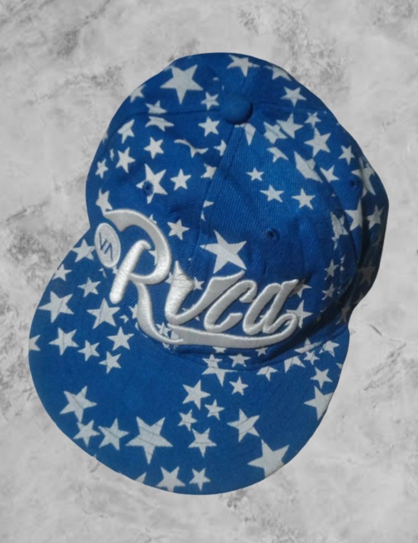 RVCA Star Print Cap (Category: Caps & Hats) located in Aroroy. Submitted by abouttocome (Listing ID 1422240017, Image 2). Description: - RVCA cap - Blue base with white star pattern - White RVCA logo on front - Red and white striped underside of brim - Adjustable strap for a custom fit.