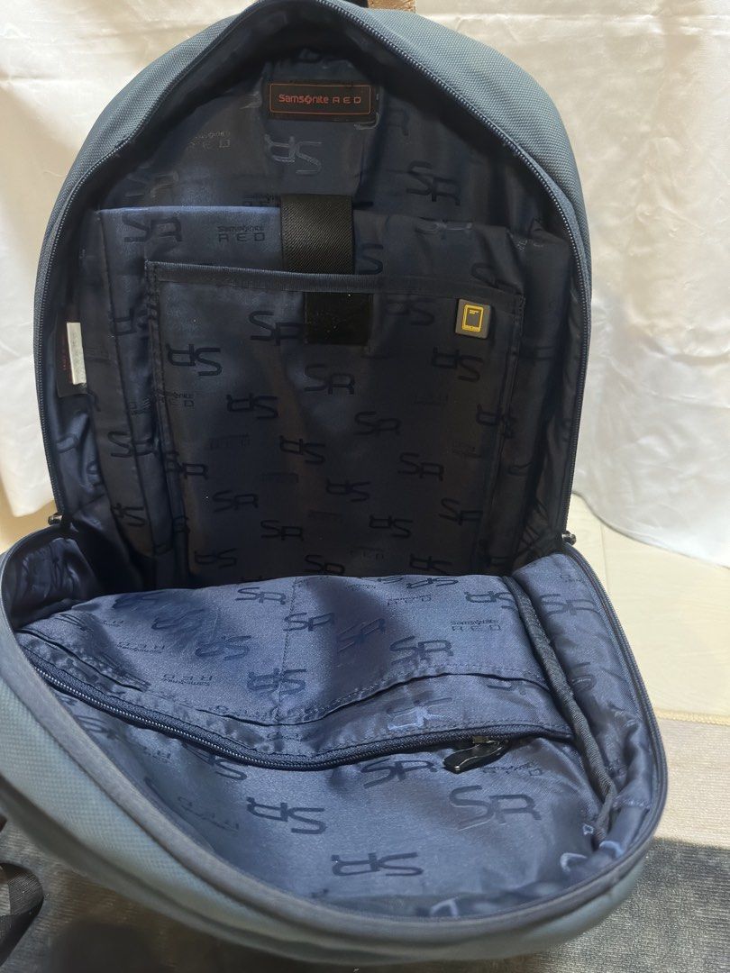 Samsonite Red Backpack (Category: Backpacks) located in San Pablo. Submitted by donaya_luxe (Listing ID 1422307696, Image 3). Description: Samsonite Red backpack features a navy blue exterior with brown leather accents. It has multiple compartments, including a padded laptop sleeve. The back panel is made of breathable mesh for comfort. The backpack has adjustable shoulder straps and a top handle. The interior lining is navy blue with the Samsoni