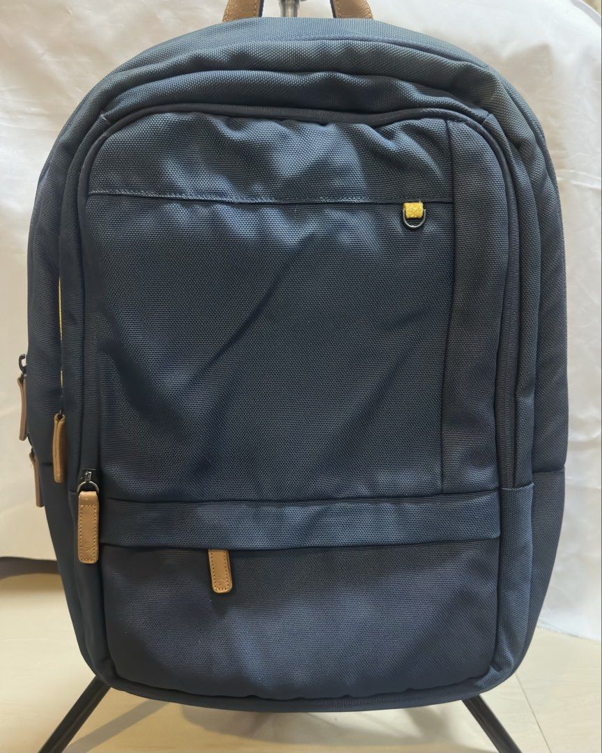 Samsonite Red Backpack (Category: Backpacks) located in San Pablo. Submitted by donaya_luxe (Listing ID 1422307696, Image 1). Description: Samsonite Red backpack features a navy blue exterior with brown leather accents. It has multiple compartments, including a padded laptop sleeve. The back panel is made of breathable mesh for comfort. The backpack has adjustable shoulder straps and a top handle. The interior lining is navy blue with the Samsoni