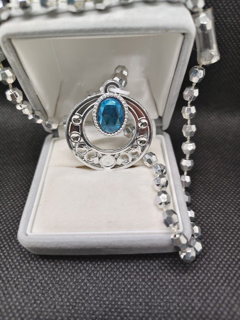 Silver Pendant Necklace with Blue Gem (Category: Necklaces) located in San Mateo. Submitted by joryee (Listing ID 1422305486, Image 2). Description: - Silver necklace with a circular pendant - Intricate detailing on the pendant - Features a vibrant blue gemstone - Beaded chain design - Suitable for various occasions.
