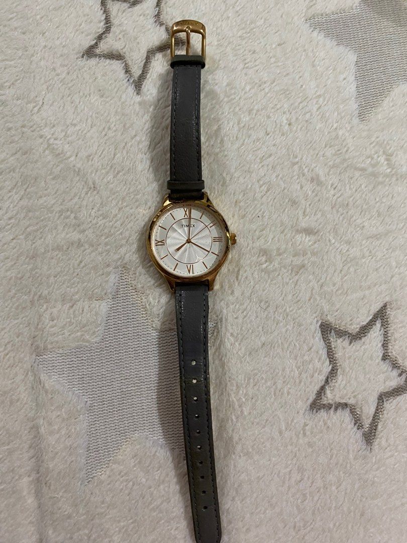 Authentic Timex Watch with Grey Leather Strap (Category: Women's Watches) located in Taguig. Submitted by jaebae_ (Listing ID 1422378834, Image 2). Description: - Authentic Timex watch; no issue; needs new battery lang - Gold-tone case - White dial with Roman numeral markers - Unique textured center - Grey leather strap - Classic design - Suitable for everyday wear - Timex logo on the back .