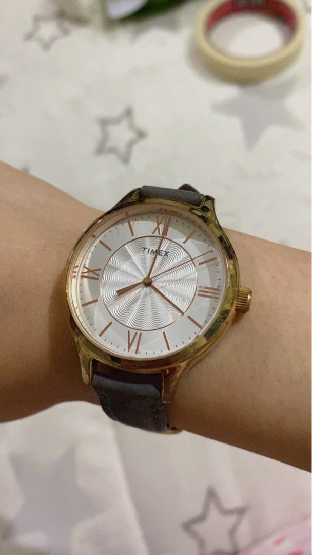 Authentic Timex Watch with Grey Leather Strap (Category: Women's Watches) located in Taguig. Submitted by jaebae_ (Listing ID 1422378834, Image 1). Description: - Authentic Timex watch; no issue; needs new battery lang - Gold-tone case - White dial with Roman numeral markers - Unique textured center - Grey leather strap - Classic design - Suitable for everyday wear - Timex logo on the back .