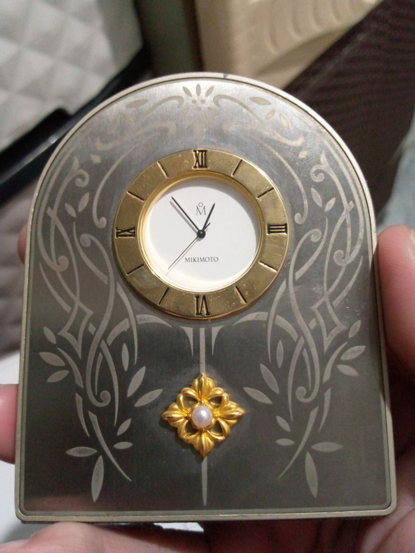 Vintage Mikimoto Decorative Clock (Category: Clocks) located in Imus. Submitted by chadrich_05 (Listing ID 1422385147, Image 1). Description: Working with new battery - Mikimoto decorative clock - Gold-toned clock face - Roman numerals - Pearl accent - Silver-toned frame with floral designs - Displays the Mikimoto logo - Perfect for display.