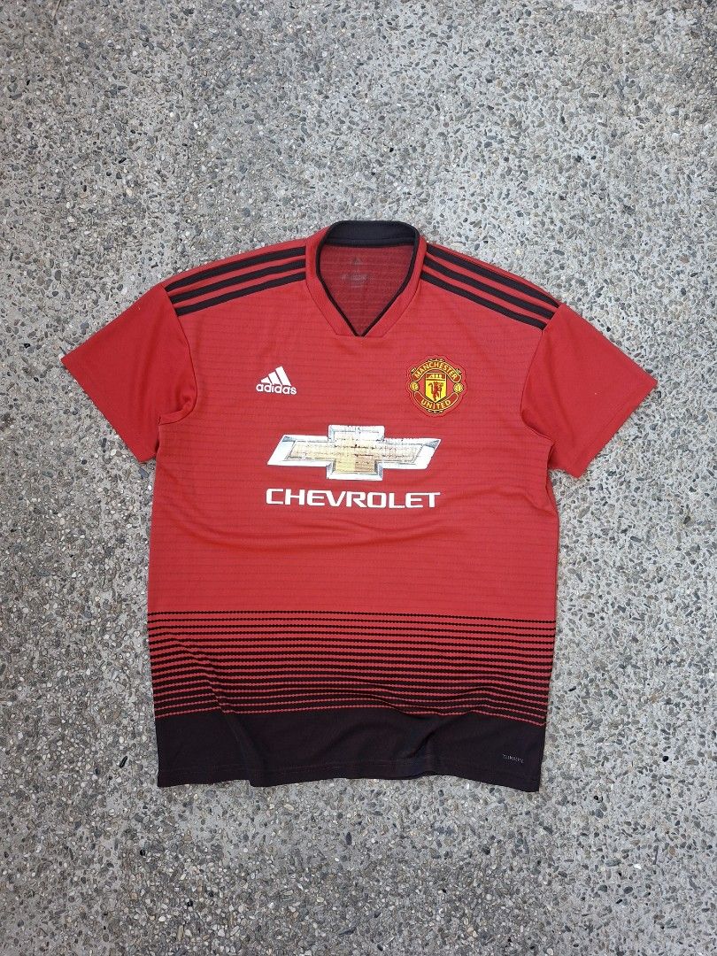 Adidas Manchester United Jersey (Category: Activewear) located in Marikina City. Submitted by 2nd_chancedrips (Listing ID 1419197096, Image 1). Description: -authentic -21.5 x 26.5 -m on tag -crackprints Red Manchester United jersey with the Chevrolet logo. It features the Adidas logo and the Manchester United crest. The jersey has black stripes on the shoulders and a black collar. The tag indicates the jersey was made in 04/18. The material comp
