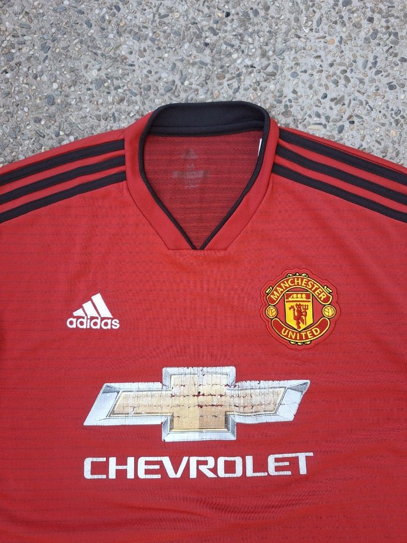 Adidas Manchester United Jersey (Category: Activewear) located in Marikina City. Submitted by 2nd_chancedrips (Listing ID 1419197096, Image 2). Description: -authentic -21.5 x 26.5 -m on tag -crackprints Red Manchester United jersey with the Chevrolet logo. It features the Adidas logo and the Manchester United crest. The jersey has black stripes on the shoulders and a black collar. The tag indicates the jersey was made in 04/18. The material comp