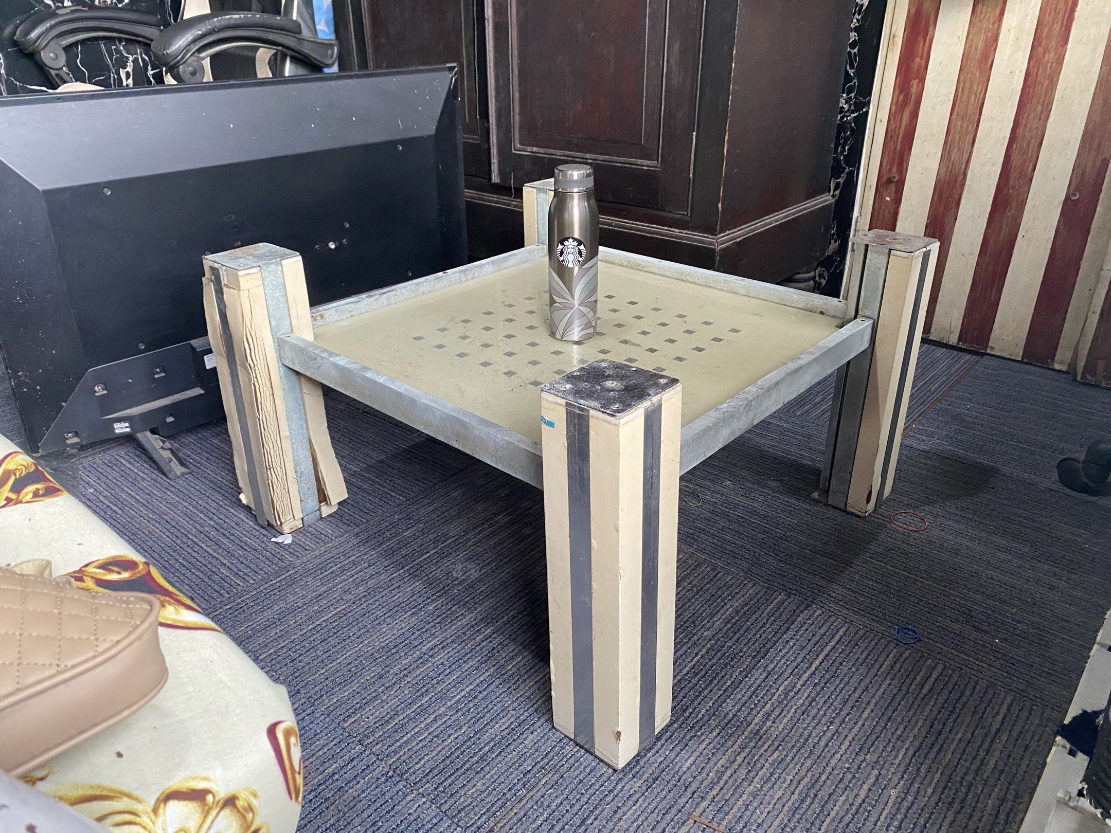 Center Table Stand (Category: Tables & Sets) located in Caloocan City. Submitted by ljhvrl (Listing ID 1419256281, Image 3). Description: - Square center table - Metal frame - Perforated tabletop - Four sturdy legs with wooden and metal design - Ideal for living rooms and other spaces - Starbucks tumbler included for size reference - Functional and stylish design .