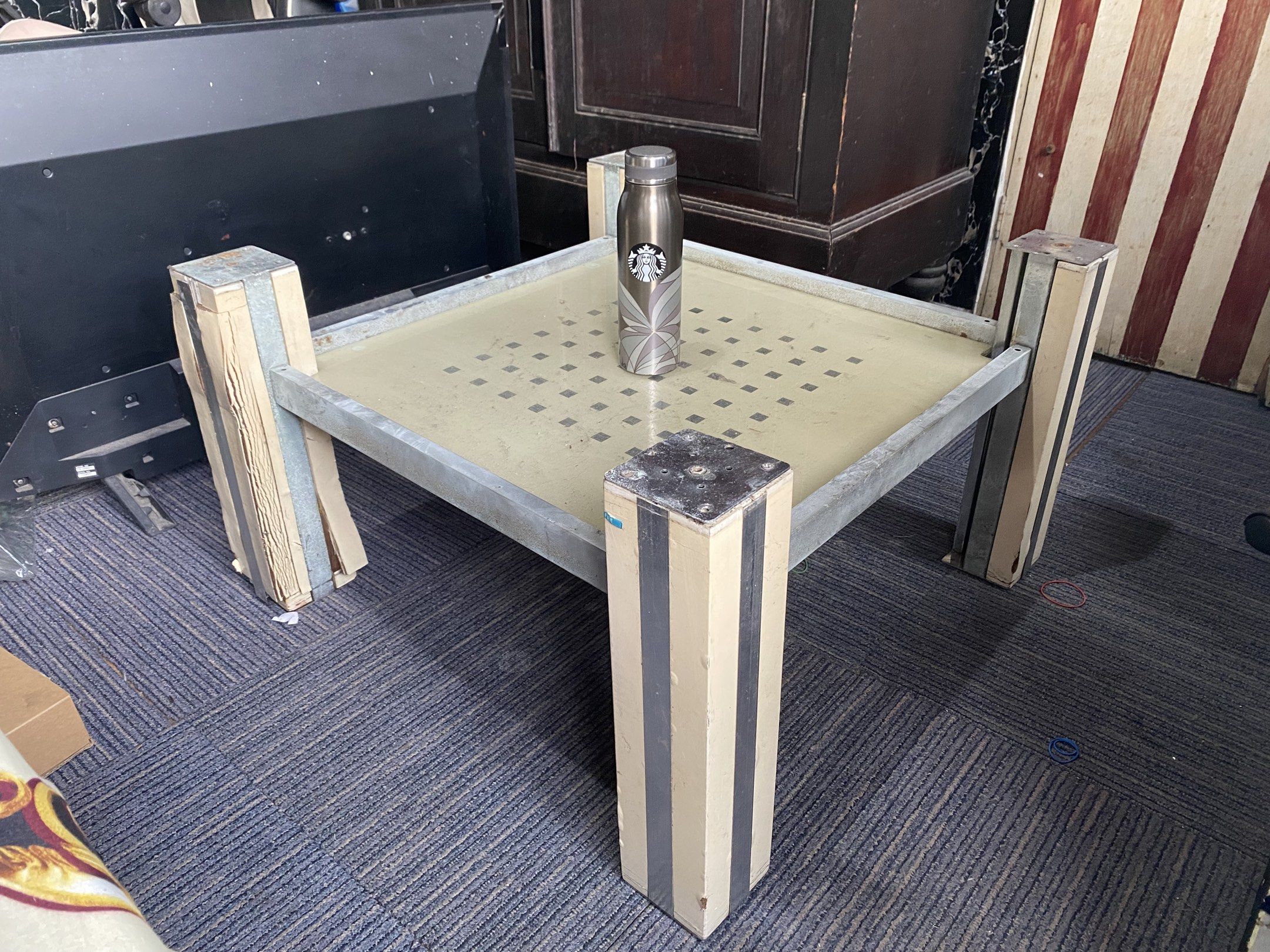 Center Table Stand (Category: Tables & Sets) located in Caloocan City. Submitted by ljhvrl (Listing ID 1419256281, Image 2). Description: - Square center table - Metal frame - Perforated tabletop - Four sturdy legs with wooden and metal design - Ideal for living rooms and other spaces - Starbucks tumbler included for size reference - Functional and stylish design .