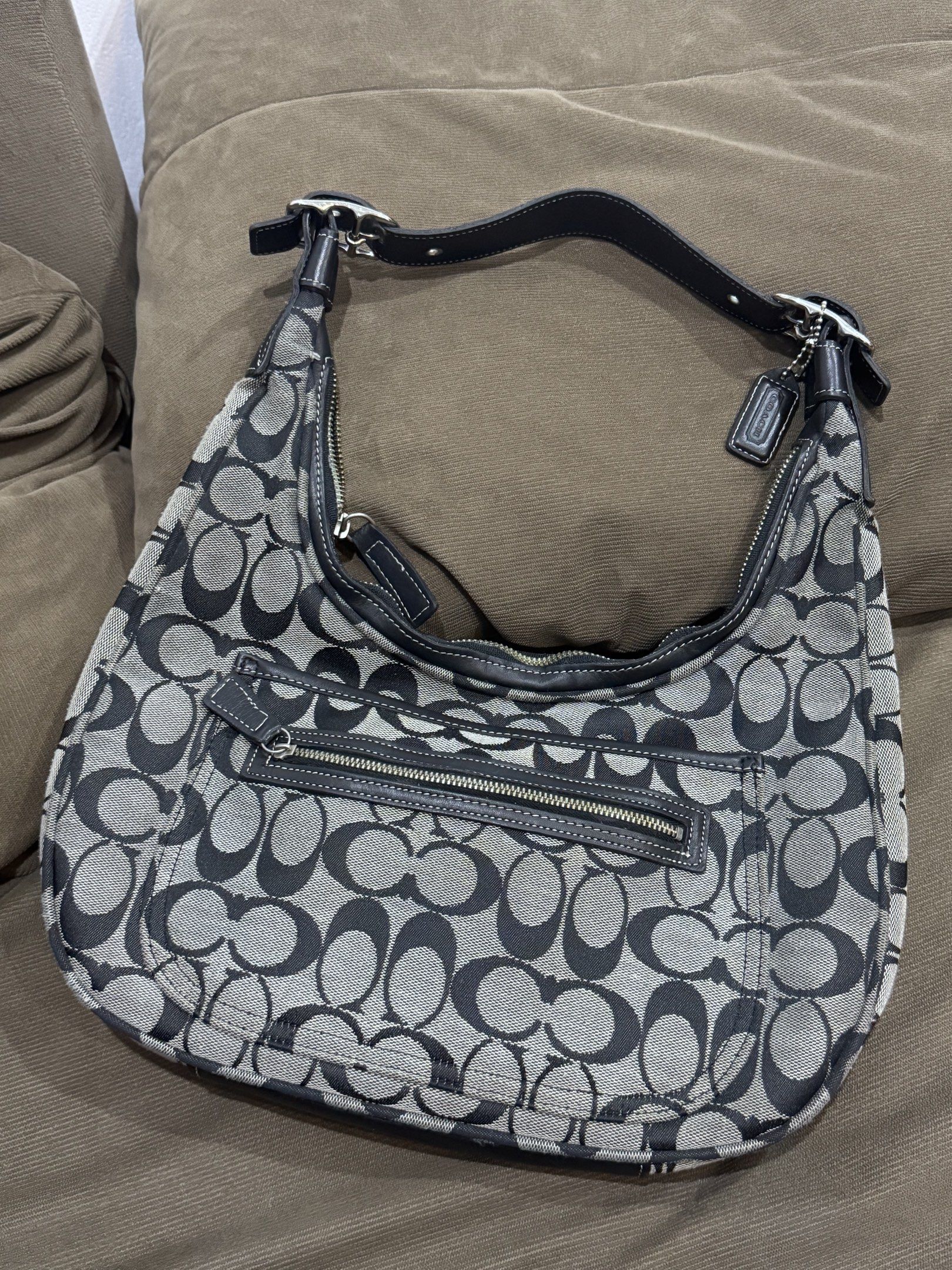 Coach Signature Hobo Bag (Category: Shoulder Bags) located in Legazpi City. Submitted by shopflorence (Listing ID 1419218954, Image 1). Description: - Authentic Coach hobo bag - Signature black and gray pattern - Secure zip closure - Convenient exterior pocket - Comfortable leather strap - Includes iconic Coach hang tag - Coach leather tag with serial number inside - Stylish silver hardware - Spacious interior for your essentials ISSUES: all zipp