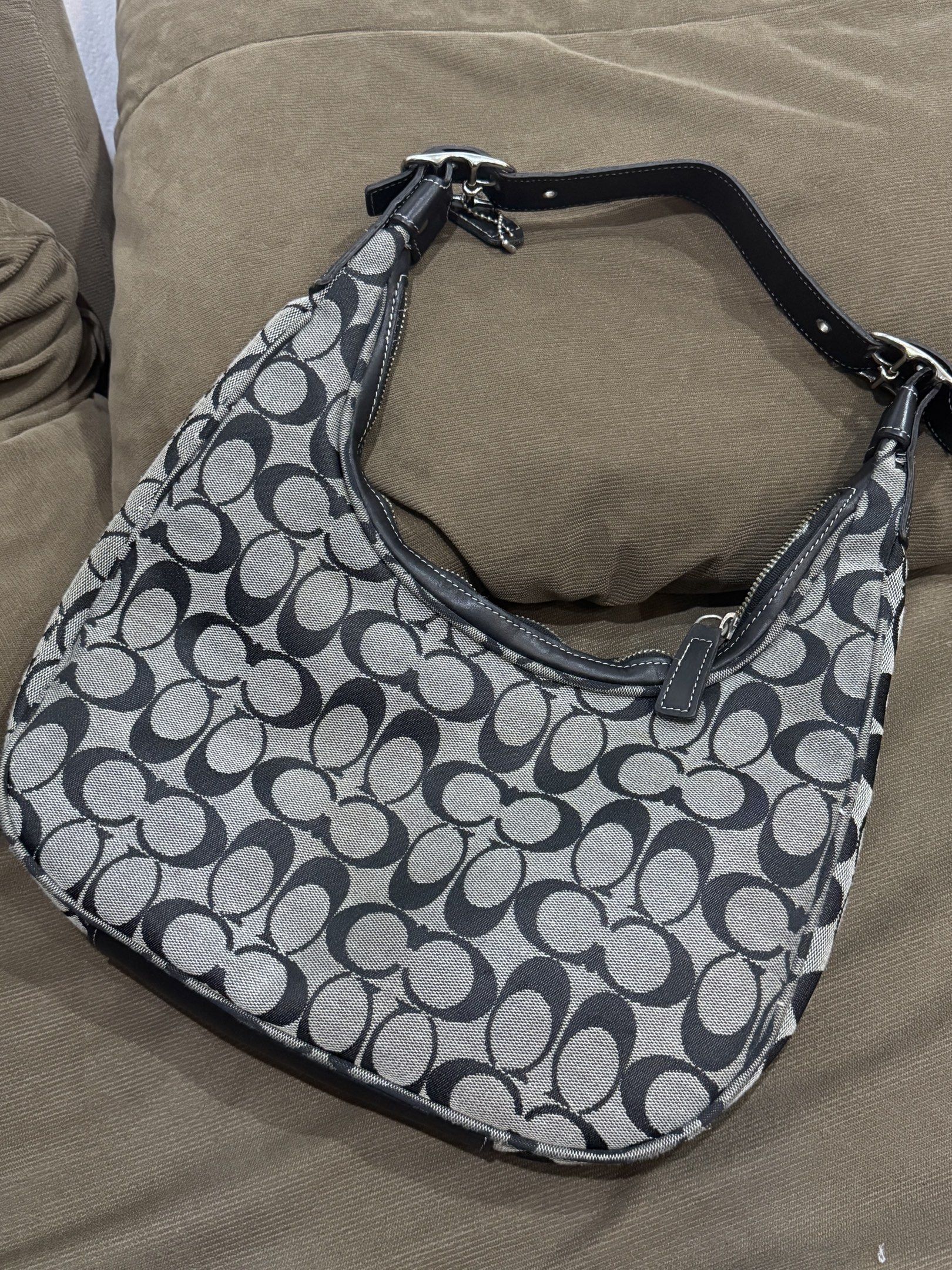 Coach Signature Hobo Bag (Category: Shoulder Bags) located in Legazpi City. Submitted by shopflorence (Listing ID 1419218954, Image 2). Description: - Authentic Coach hobo bag - Signature black and gray pattern - Secure zip closure - Convenient exterior pocket - Comfortable leather strap - Includes iconic Coach hang tag - Coach leather tag with serial number inside - Stylish silver hardware - Spacious interior for your essentials ISSUES: all zipp