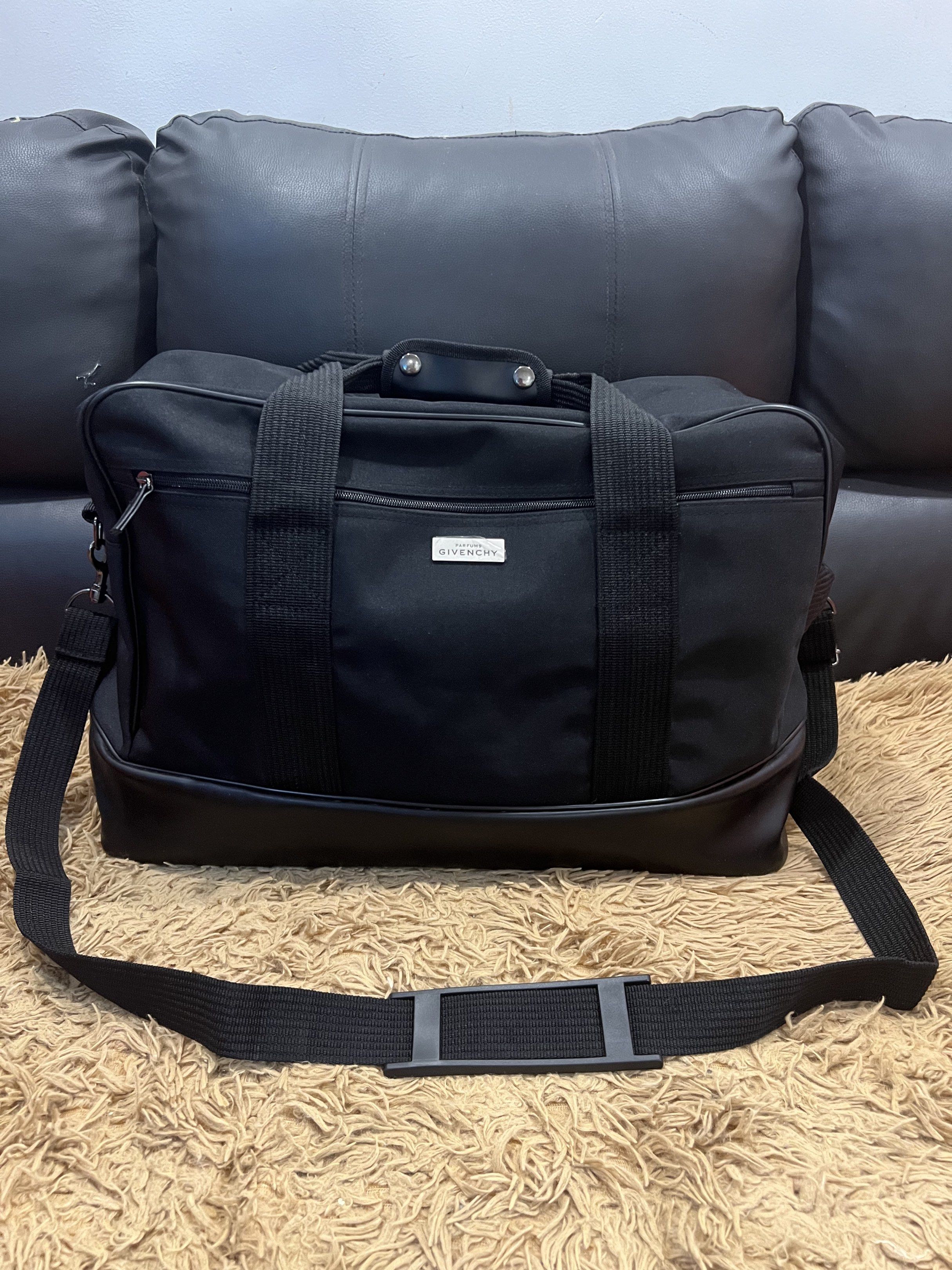 Givenchy Black Duffle Bag (Category: Luxury Bags & Wallets) located in Lipa City. Submitted by thyra06 (Listing ID 1419253554, Image 1). Description: - Authentic Givenchy duffle bag - Classic black color - Includes a detachable shoulder strap and top handles - Features the iconic Givenchy logo - Secure zippered main compartment - Constructed with durable materials.