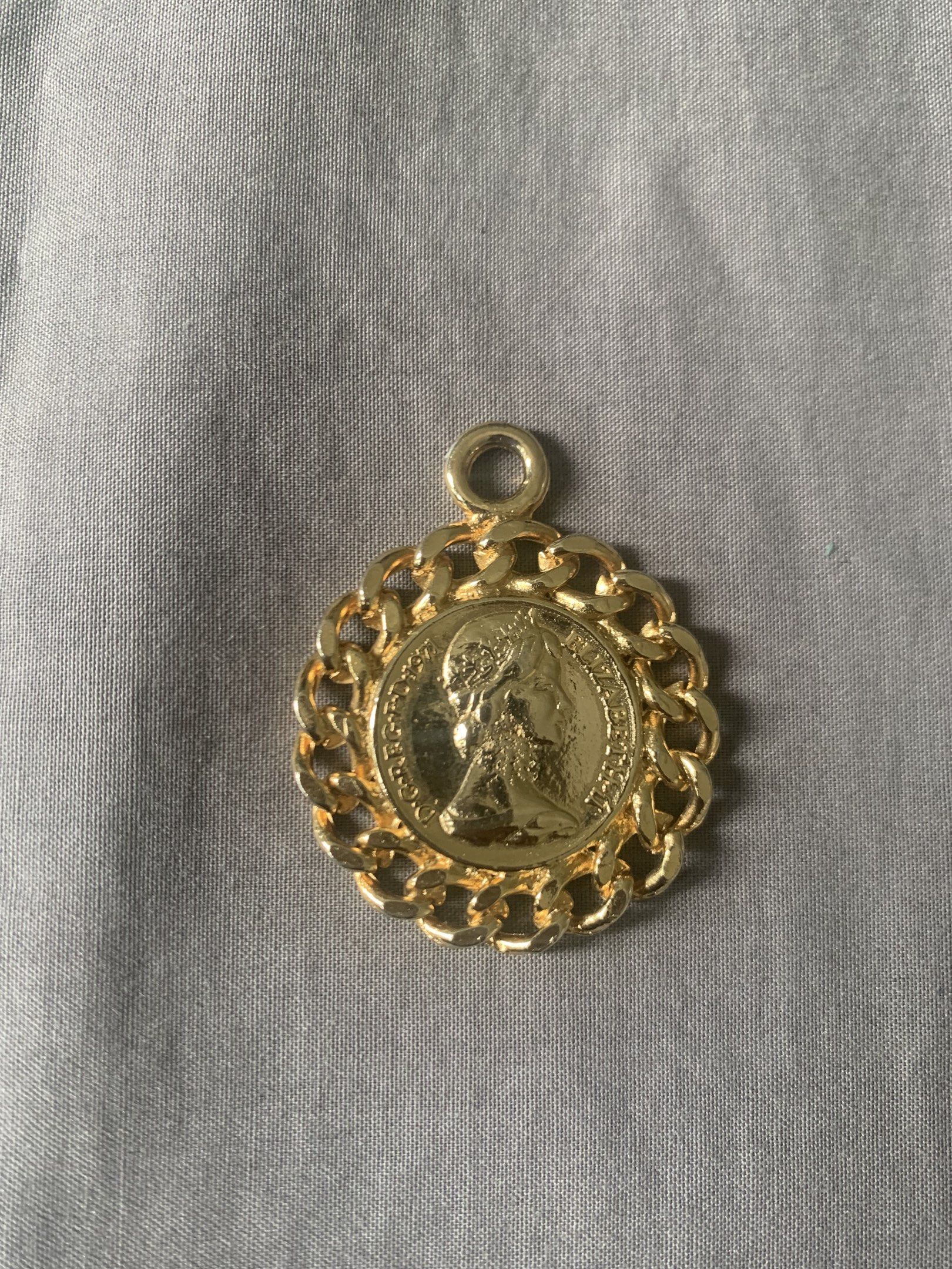 Gold Coin Pendant with Chain (Category: Charms) located in Tabuk. Submitted by qurst (Listing ID 1419310534, Image 1). Description: - Gold-toned coin pendant - Chain border design - Features a portrait - Circular shape - Includes loop for necklace/bracelet.