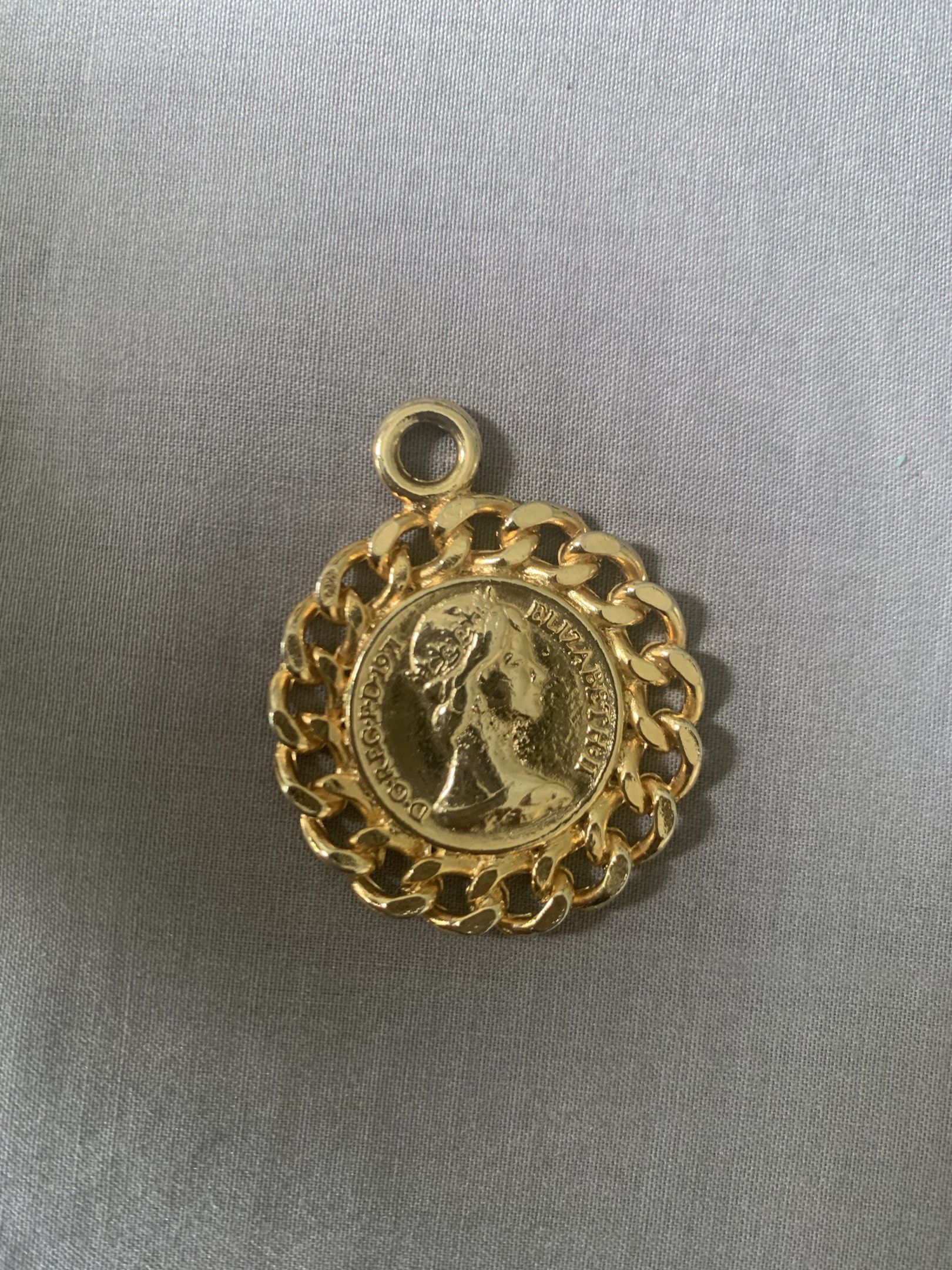 Gold Coin Pendant with Chain (Category: Charms) located in Tabuk. Submitted by qurst (Listing ID 1419310534, Image 2). Description: - Gold-toned coin pendant - Chain border design - Features a portrait - Circular shape - Includes loop for necklace/bracelet.