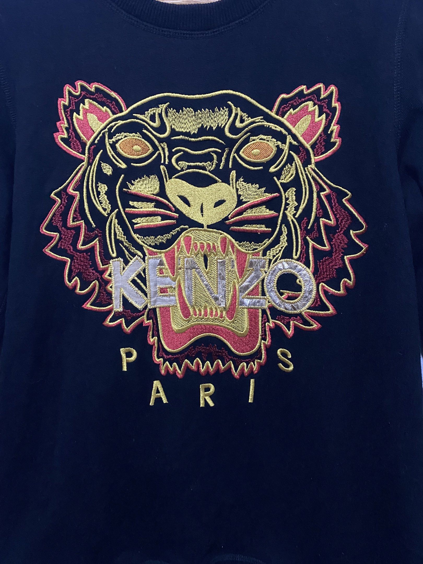 Kenzo Paris Tiger Sweatshirt - Black - Medium (Category: Coats, Jackets and Outerwear) located in Sorsogon. Submitted by ninjathrift (Listing ID 1419384006, Image 2). Description: - Authentic Kenzo Paris sweatshirt - Black color - Features the iconic tiger embroidery - Crew neck design - Size: Medium - Made in Portugal - Long sleeves - Visible care label - Embroidered Kenzo logo on the front -A bit of print issue in some letters of "KENZO".