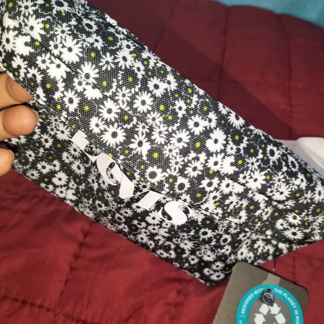 Levi's Floral Waist Bag (Category: Belt bags, Clutches and Pouches) located in Urdaneta. Submitted by bernizonlineshop (Listing ID 1419209570, Image 3). Description: - Levi's waist bag with a vibrant floral pattern. - Features a stylish white strap. - Main compartment with secure zipper closure. - Includes an interior tag. - Authentic Levi's tag with logo and recycling symbol. -bought from Canada -2 zip pockets.