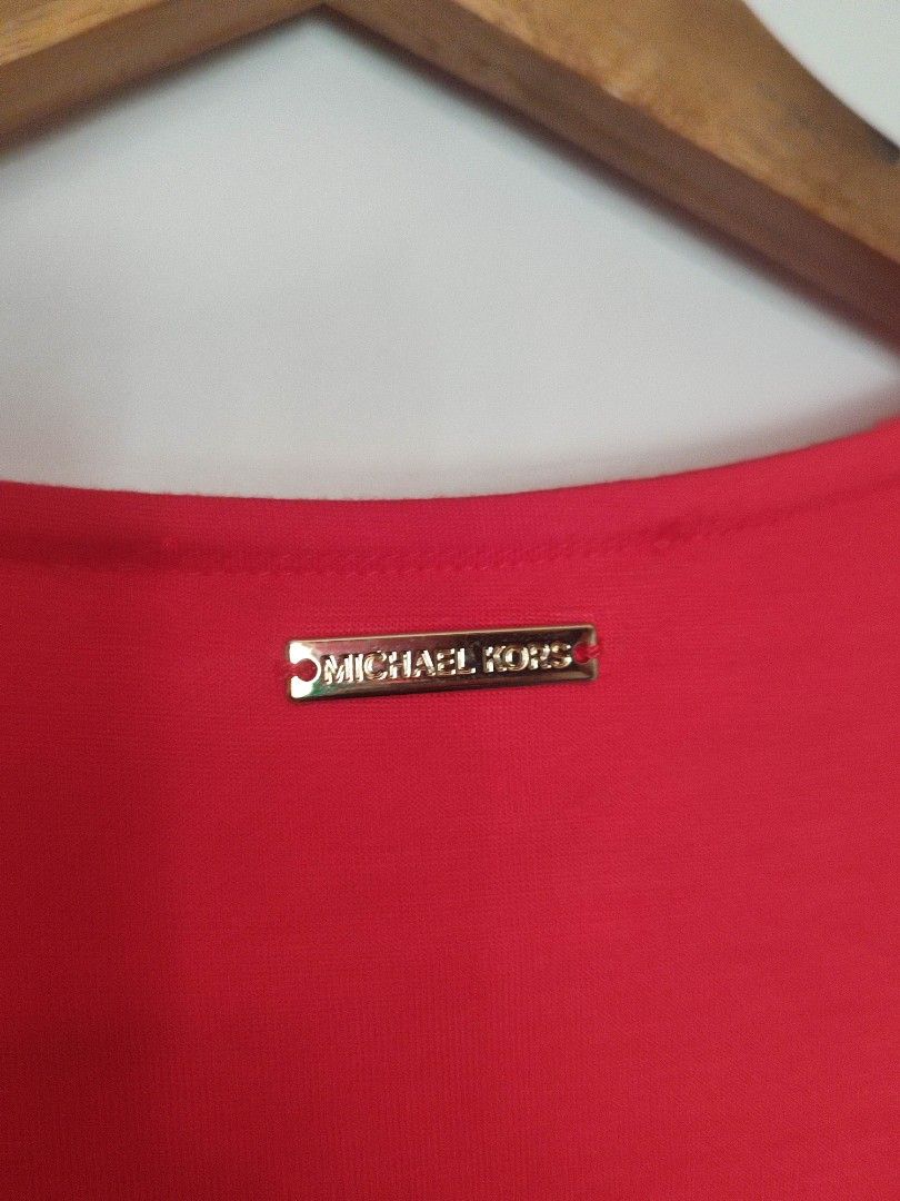 Michael Kors Sleeveless V-Neck Top (Category: Sleeveless) located in Mangaldan. Submitted by michelle_2004 (Listing ID 1419289155, Image 2). Description: Bright red sleeveless top from Michael Kors. Features a V-neck design. The tag indicates the size is L. The top has a layered design at the bottom. The Michael Kors logo is visible on the neckline..