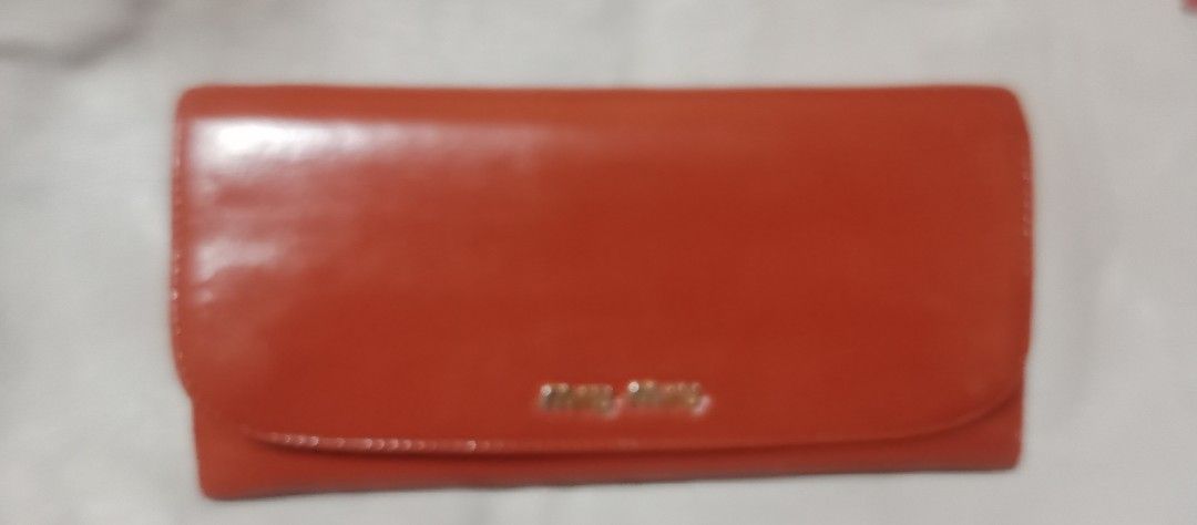 Miu Miu Leather Wallet (Category: Luxury Bags & Wallets) located in Makati City. Submitted by cd910625 (Listing ID 1419236132, Image 1). Description: Miu Miu wallet features a bi-fold design with a vibrant orange exterior and a pink interior. It has multiple card slots, a zippered compartment, and a snap closure. The Miu Miu logo is visible on the exterior and the zipper pull..