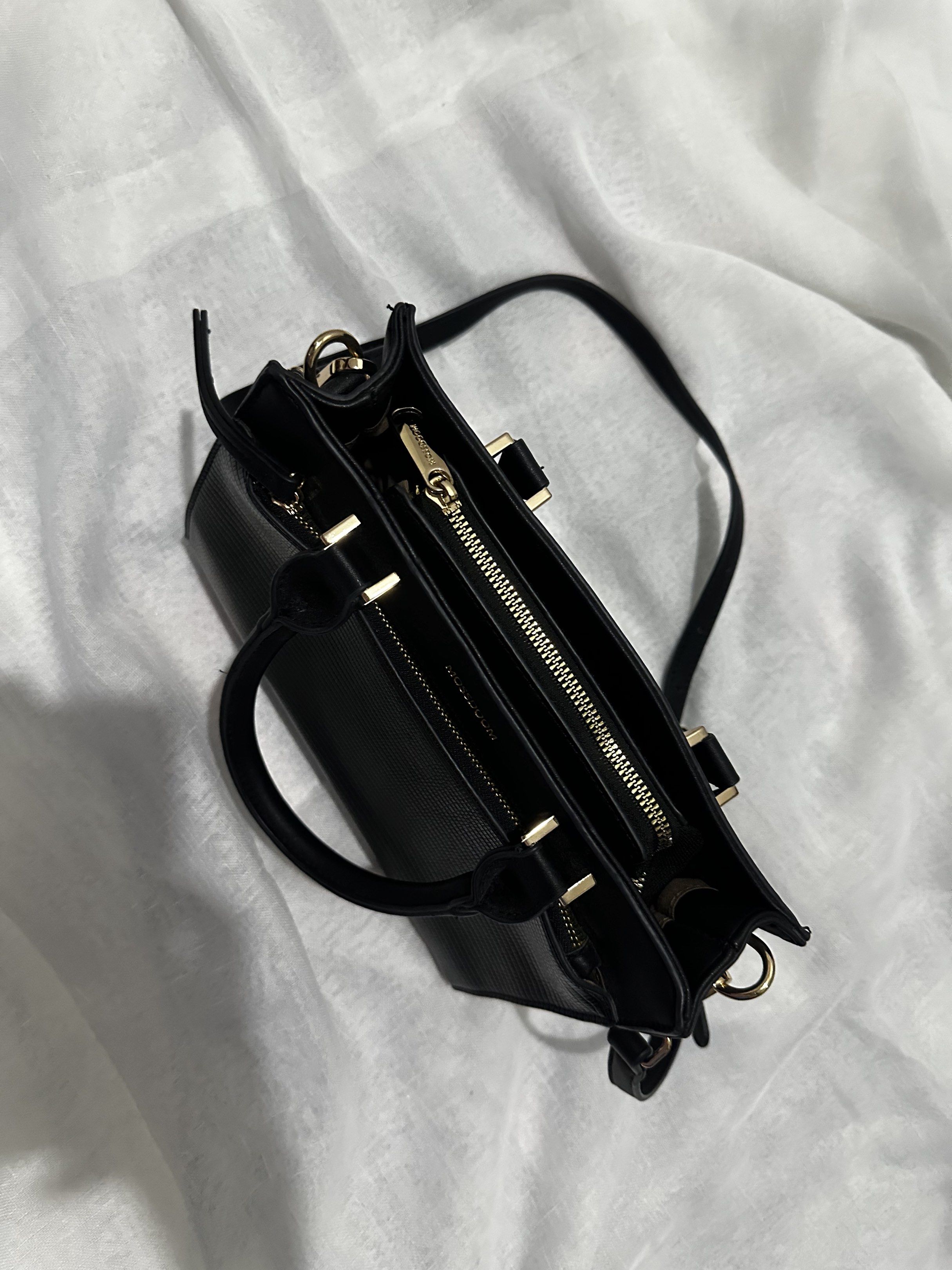 Mossdoom Black Handbag with Shoulder Strap (Category: Shoulder Bags) located in Pasay City. Submitted by j9declutter (Listing ID 1419333274, Image 2). Description: Decluttering! Selling low!!! Pick-up via grab/move it/joyride/angkas/lalamove only. NO COD! If in doubt, wag bumili 😁 You can pay thru BPi & Gcash only. Happy shopping! ❤️❤️❤️ - Black Mossdoom handbag - Top handle and detachable shoulder strap - Textured exterior - Zippered main compa