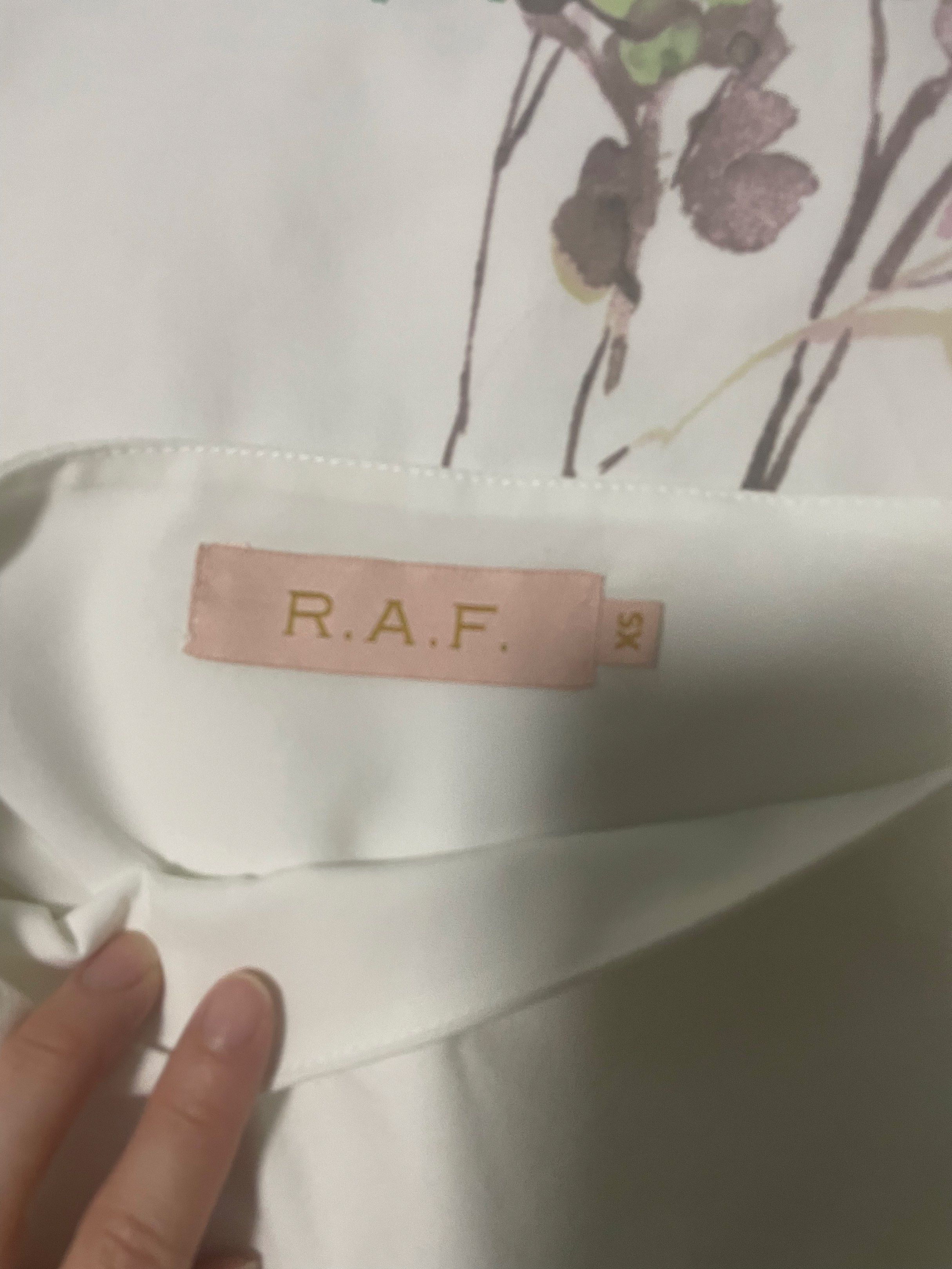 R.A.F. White Top XS (Category: Sleeveless) located in Quezon City. Submitted by lillyshop (Listing ID 1419337976, Image 2). Description: - R.A.F. white cropped top - Size: XS - Features a square neckline - Long, puffed sleeves - Lightweight fabric - Small logo detail.