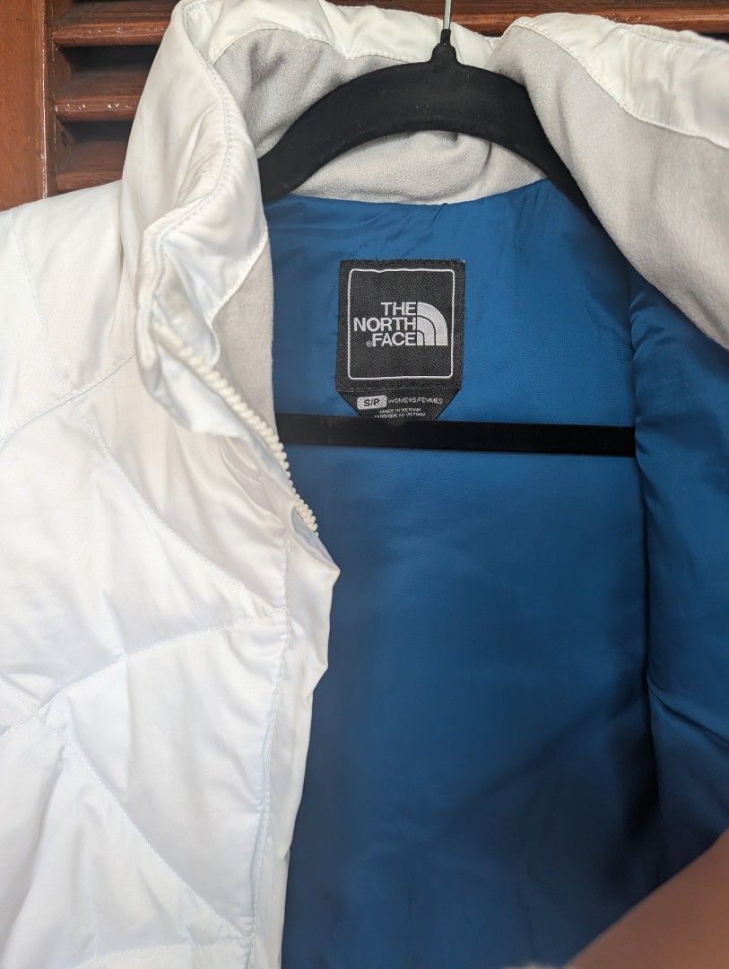 The North Face White Vest (Category: Coats, Jackets and Outerwear) located in Baguio. Submitted by jamstd (Listing ID 1419269458, Image 2). Description: - The North Face white vest - Quilted design - High collar - Front zipper closure - Two side pockets - Blue lining - The North Face logo on chest - Size: SP.