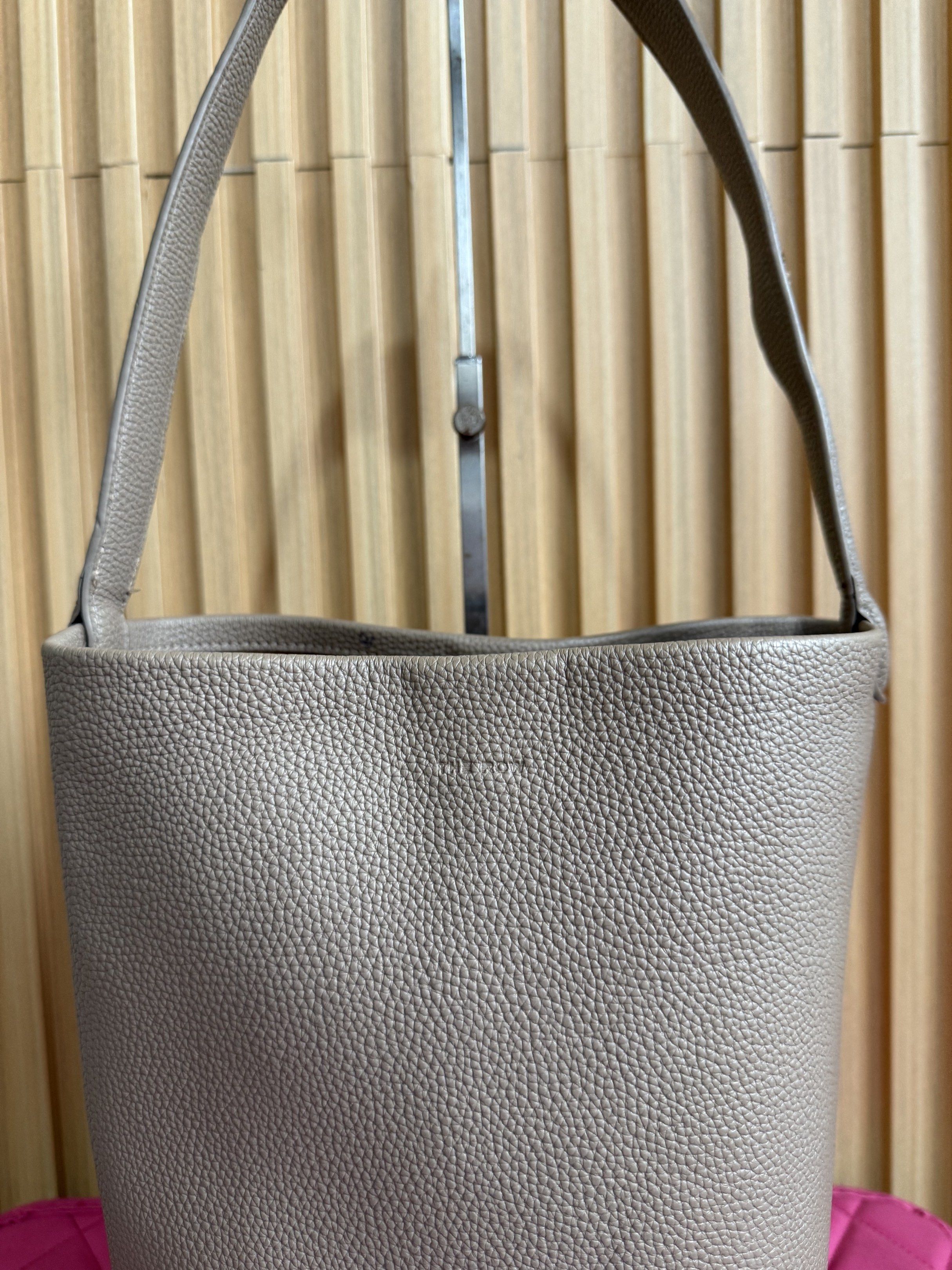 The Row Leather Bucket Bag (Category: Luxury Bags & Wallets) located in Lipa City. Submitted by thyra06 (Listing ID 1419389608, Image 3). Description: - The Row bucket bag - Crafted from textured leather - Single shoulder strap - Spacious interior - Versatile neutral color - Lined interior - Minor imperfection on strap.
