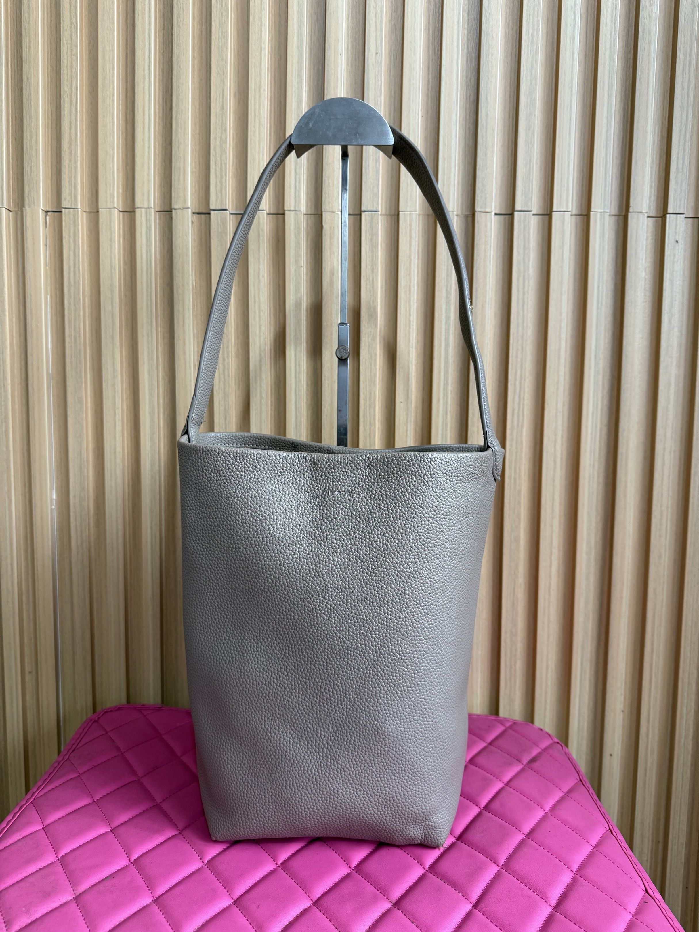 The Row Leather Bucket Bag (Category: Luxury Bags & Wallets) located in Lipa City. Submitted by thyra06 (Listing ID 1419389608, Image 1). Description: - The Row bucket bag - Crafted from textured leather - Single shoulder strap - Spacious interior - Versatile neutral color - Lined interior - Minor imperfection on strap.