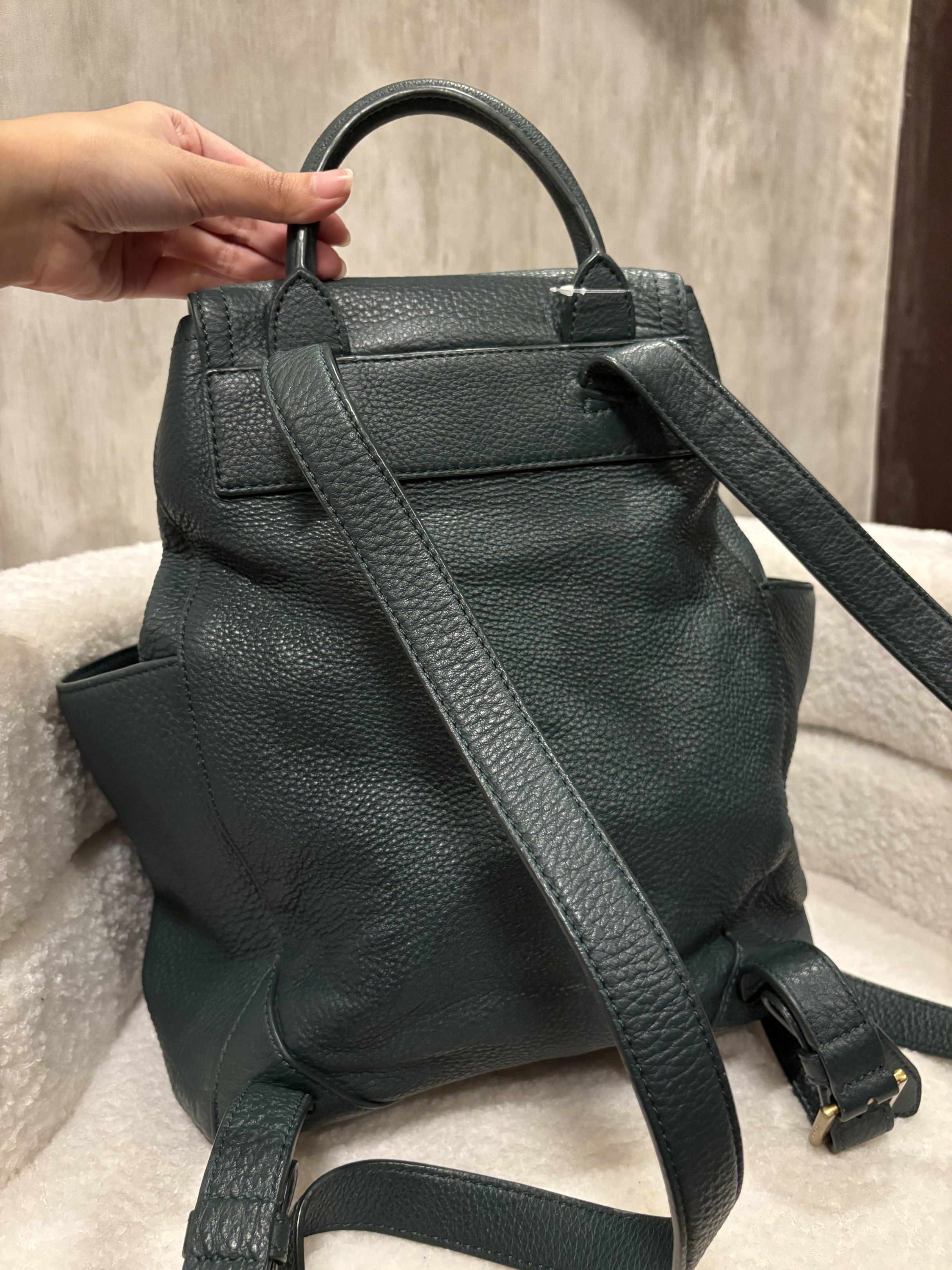 Tory Burch Leather Backpack (Category: Luxury Bags & Wallets) located in Manila. Submitted by _thepursela (Listing ID 1419313449, Image 2). Description: Stylish Tory Burch backpack in a deep teal color. Features a drawstring closure, top handle, and side pockets. The interior is lined with the Tory Burch logo pattern. The backpack has adjustable straps and a gold-tone logo emblem on the front..
