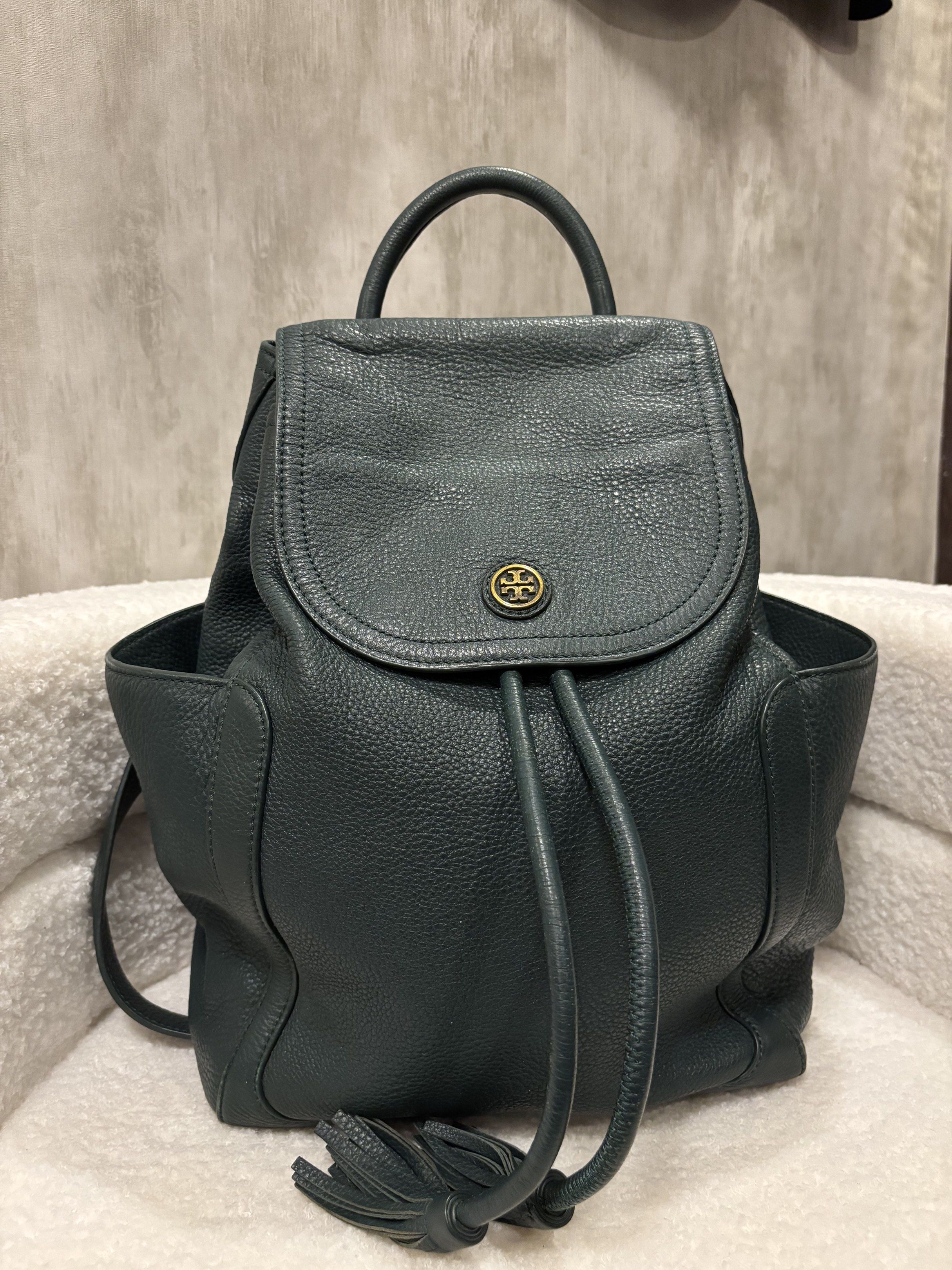 Tory Burch Leather Backpack (Category: Luxury Bags & Wallets) located in Manila. Submitted by _thepursela (Listing ID 1419313449, Image 1). Description: Stylish Tory Burch backpack in a deep teal color. Features a drawstring closure, top handle, and side pockets. The interior is lined with the Tory Burch logo pattern. The backpack has adjustable straps and a gold-tone logo emblem on the front..