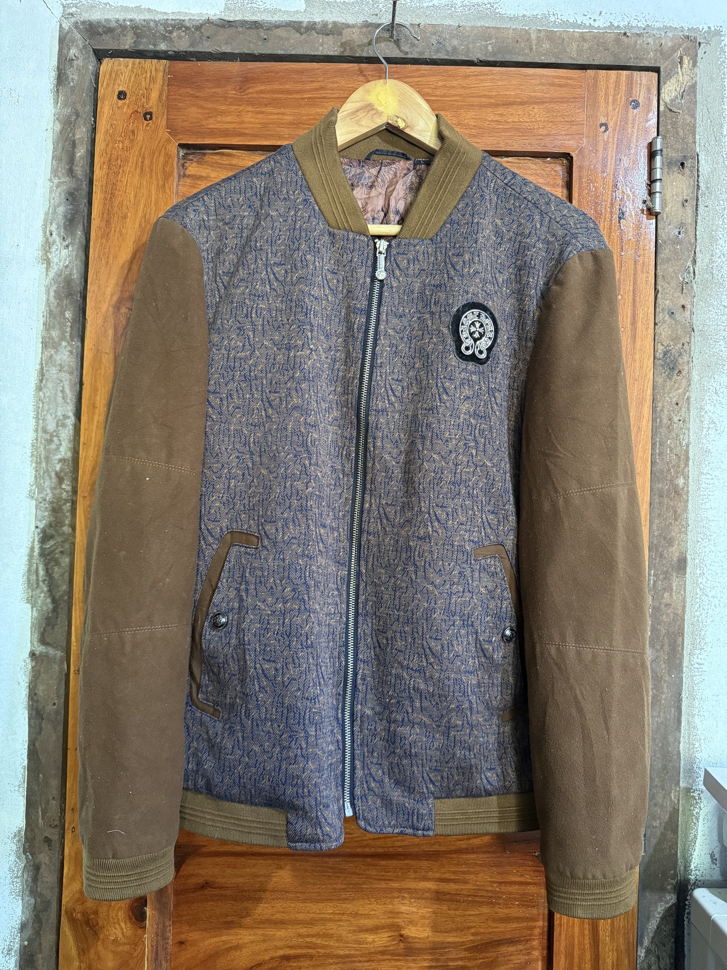Varsity Jacket with Patch (Category: Coats, Jackets and Outerwear) located in Manila. Submitted by keepercollection (Listing ID 1419204902, Image 1). Description: - Stylish varsity jacket - Unique patterned body - Contrasting brown sleeves - Front zipper closure - Chest patch detail - Brown collar and cuffs - Patterned design on the back - Versatile wardrobe piece.
