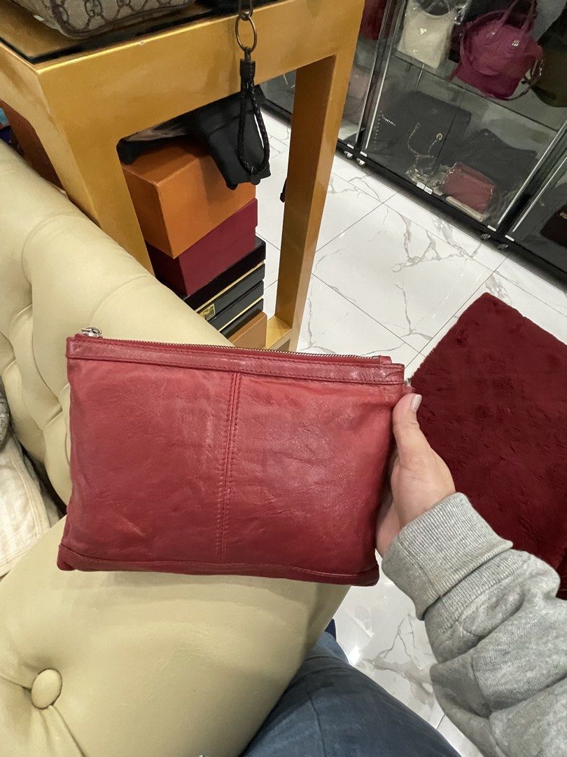 Balenciaga Red Leather Clutch (Category: Luxury Bags & Wallets) located in Davao. Submitted by jackie2276 (Listing ID 1422497867, Image 2). Description: Balenciaga clutch is made of red leather. It features a zip closure and a wrist strap. The interior is black. The brand name is visible inside the clutch. The clutch is made in Italy. The serial number is also visible..
