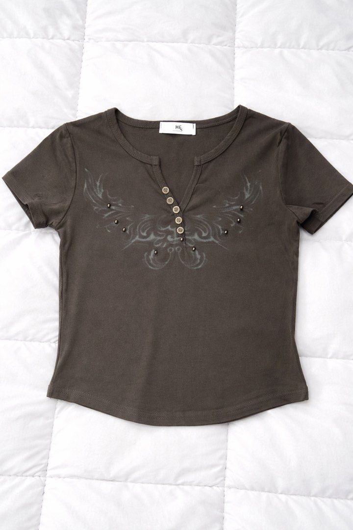 Butterfly button top (Category: Shirts) located in Quezon City. Submitted by rhaez (Listing ID 1422482983, Image 2). Description: - Henley neckline with button details - Short sleeves - Embellished front design - Soft, comfortable fabric - Dark, muted color - Versatile for various outfits.