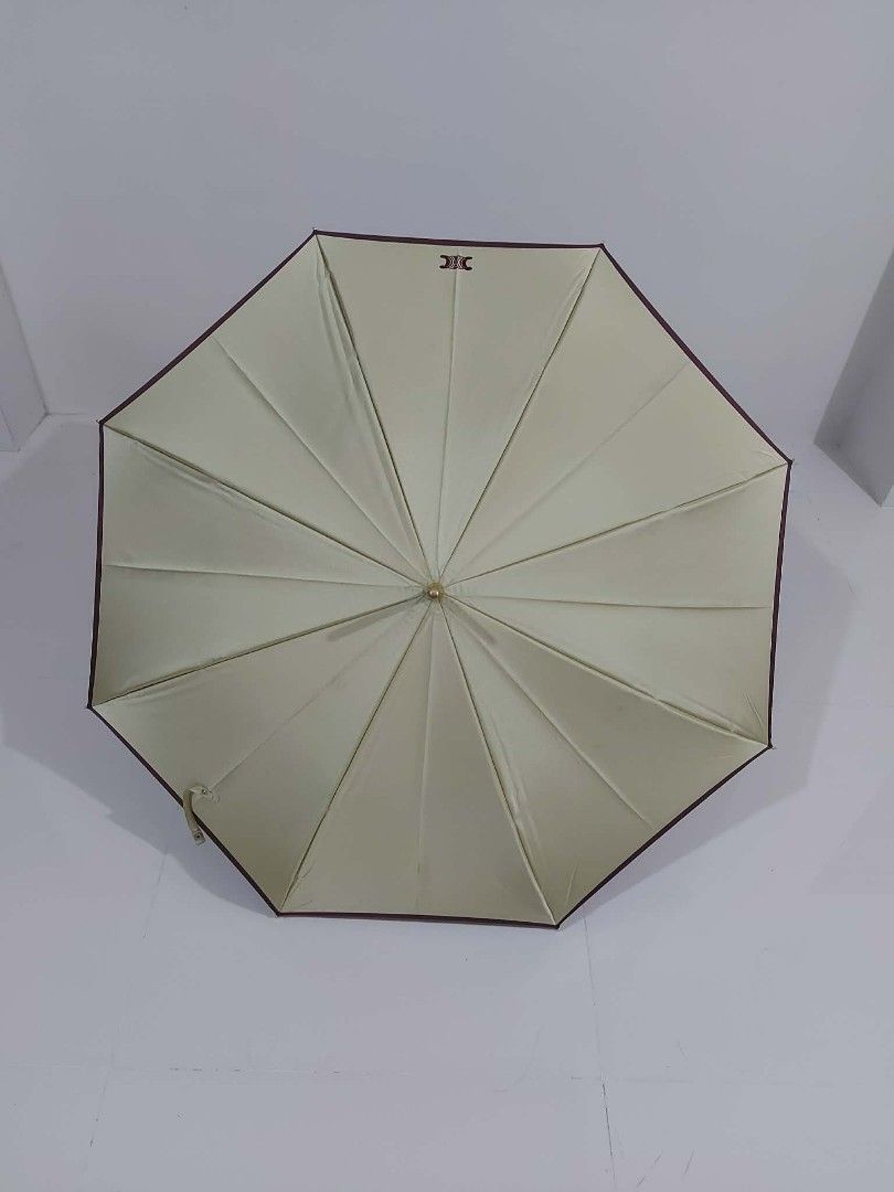 Celine Umbrella (Category: Umbrellas) located in Bayombong. Submitted by Gentlemans_ClosEt (Listing ID 1422484655, Image 1). Description: - Authentic Celine umbrella - Cream canopy with burgundy trim - Curved handle design - Celine logo visible - Secure button closure - Perfect for rainy or sunny days.