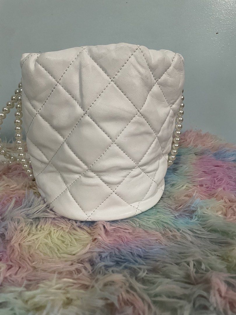 Chanel Quilted Bucket Bag with Pearl Strap (Category: Luxury Bags & Wallets) located in Pasig City. Submitted by ladyboss1012 (Listing ID 1422483728, Image 2). Description: - White quilted bucket bag - Pearl strap and gold-tone chain drawstring - Gold-tone Chanel logo - Red interior with Chanel label - Chanel logo stitched on the bottom - Made in Italy.