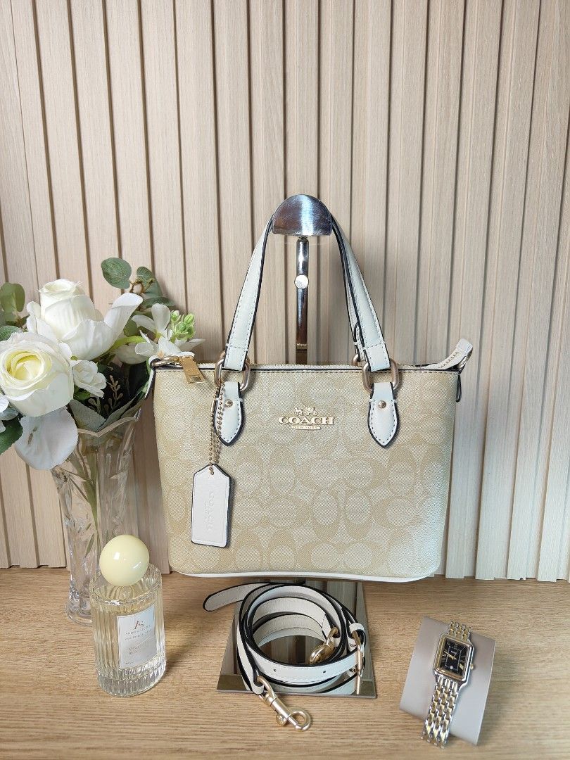 Coach Signature Mini Tote Bag (Category: Luxury Bags & Wallets) located in Naga. Submitted by demaria14 (Listing ID 1422511577, Image 1). Description: - Coach Mini Tote Bag - Signature pattern - Top zip closure - Dual top handles - Adjustable, detachable crossbody strap - Coach hangtag included - Interior slip pocket - Coach leather patch - Gold-tone hardware - Beige and white color.