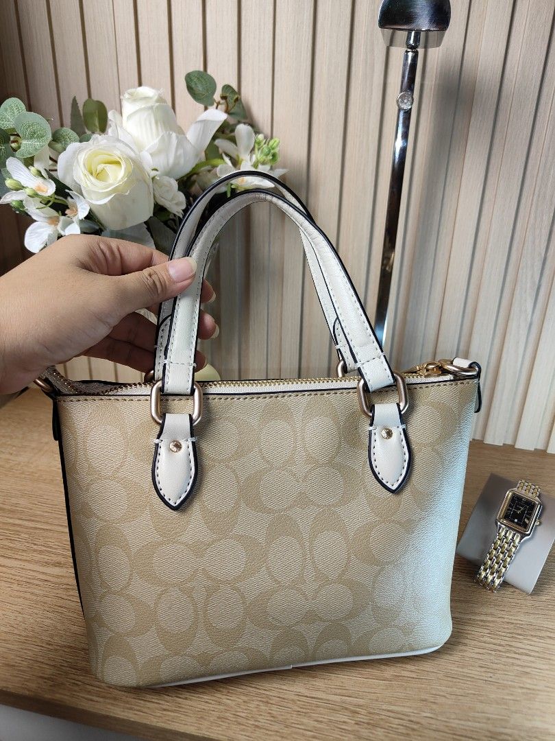 Coach Signature Mini Tote Bag (Category: Luxury Bags & Wallets) located in Naga. Submitted by demaria14 (Listing ID 1422511577, Image 2). Description: - Coach Mini Tote Bag - Signature pattern - Top zip closure - Dual top handles - Adjustable, detachable crossbody strap - Coach hangtag included - Interior slip pocket - Coach leather patch - Gold-tone hardware - Beige and white color.
