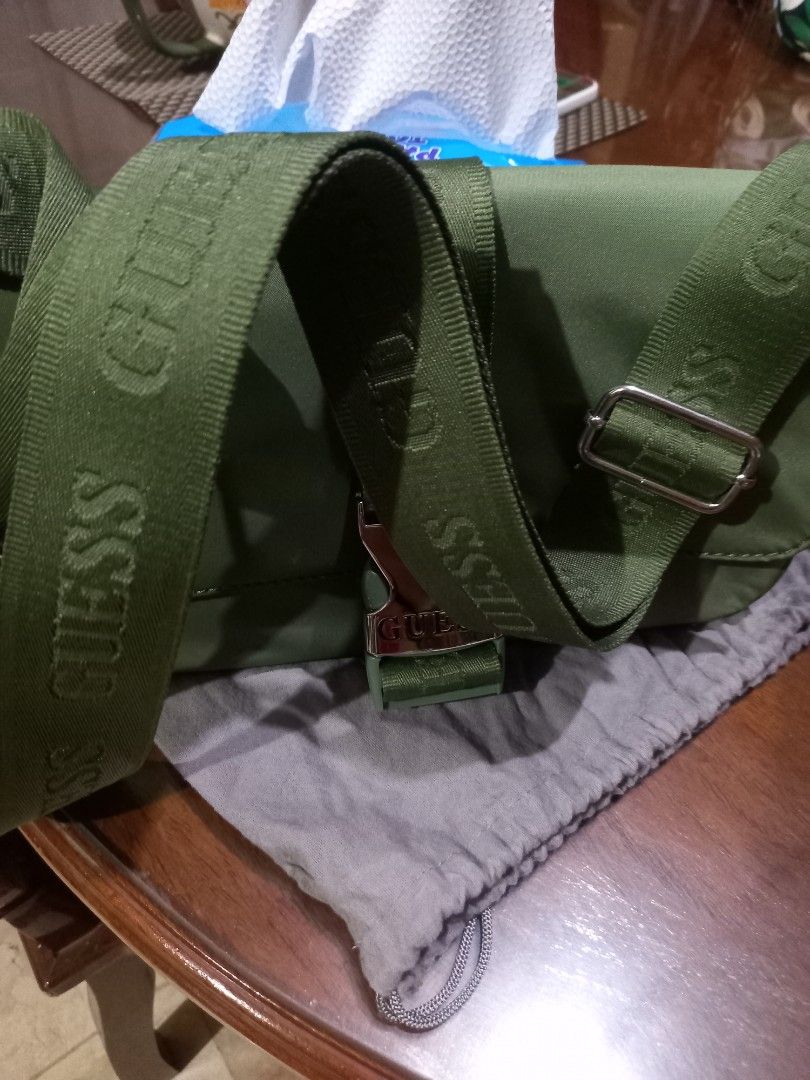 Guess Olive Green Crossbody Bag (Category: Cross-body Bags) located in Bulacan. Submitted by barlgus (Listing ID 1422495007, Image 2). Description: - Olive green Guess crossbody bag - Buckle closure with Guess logo - Adjustable strap with Guess branding - Patterned interior with multiple compartments - Includes dust bag and tags - Style: NL851221 - Color: OLIVE - Group: ALPENA.