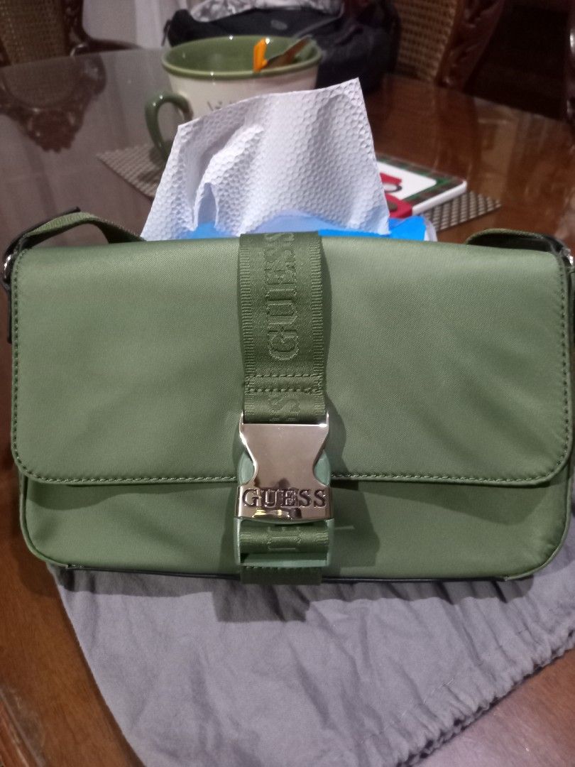 Guess Olive Green Crossbody Bag (Category: Cross-body Bags) located in Bulacan. Submitted by barlgus (Listing ID 1422495007, Image 1). Description: - Olive green Guess crossbody bag - Buckle closure with Guess logo - Adjustable strap with Guess branding - Patterned interior with multiple compartments - Includes dust bag and tags - Style: NL851221 - Color: OLIVE - Group: ALPENA.
