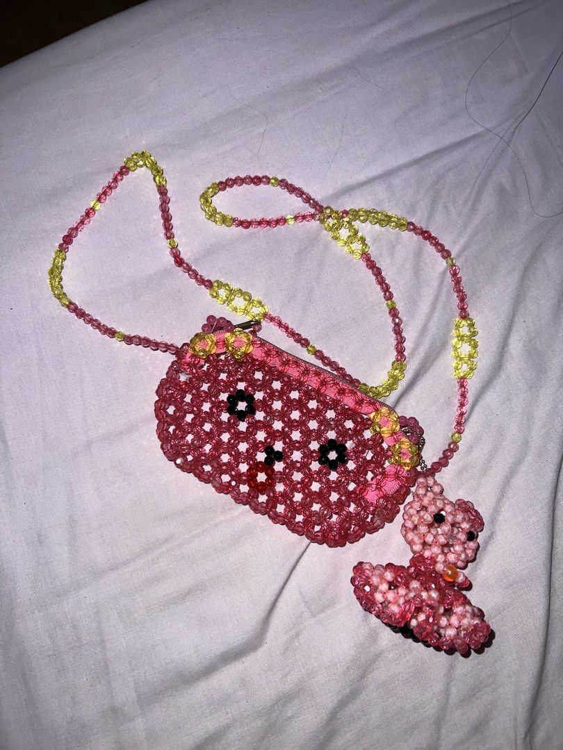 Handmade Beaded Hello Kitty Bag w/ free keychain (Category: Babies & Kids Fashion) located in Cavite. Submitted by cssndrakateg (Listing ID 1422445010, Image 1). Description: - Handmade beaded hello kitty bag - Pink and yellow color scheme - Features a small purse pendant with a hello kitty design - Perfect for adding a whimsical touch - Unique and eye-catching accessory.